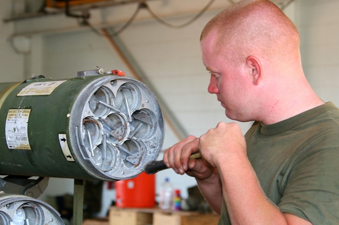 Marine Aviation Logistics Squadron 12 aviation ordnance technician and native of Longview, Texas, Cpl. Douglas L. Richardson, locks in 2.75 inch rockets into the rocket pods during Exercise Southern Frontier 2006, Sept. 18.