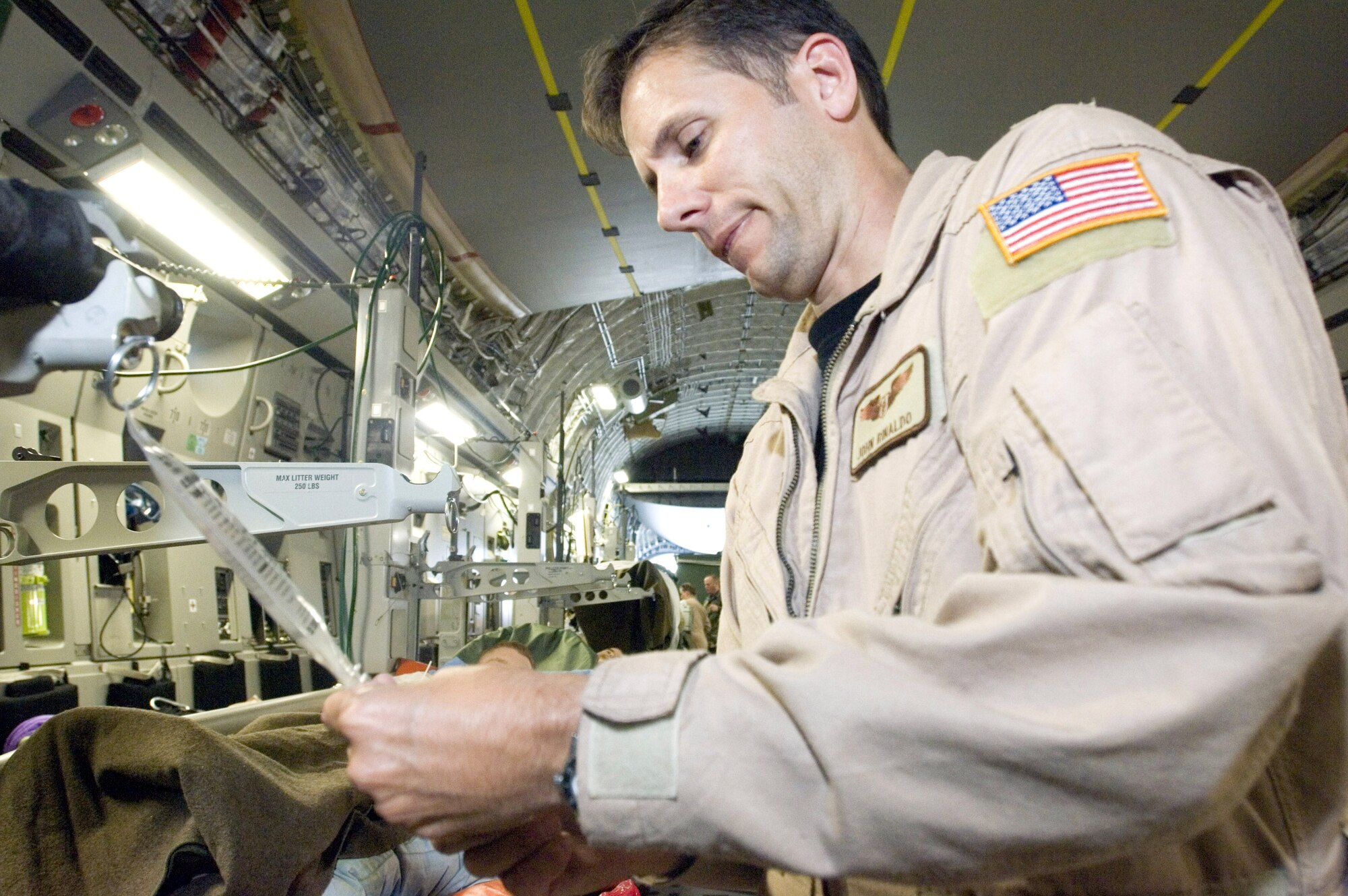 First Lt. John Rinaldo prepares to administer medicine during an aeromedical evacuation mission Sept. 18 aboard a C-17 Globemaster III. Lieutenant Rinaldo is a flight nurse serving temporary duty with the 791st Expeditionary Aeromedical Evacuation Squadron at Ramstein Air Base, Germany. (U.S. Air Force photo/Master Sgt. John E. Lasky) 
