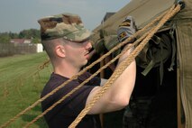 YOUNGSTOWN AIR RESERVE STATION, Ohio -- Air Force Reserve Staff Sgt. Jeffrey Hansen, a firefighter with the Civil Engineer Squadron, puts the finishing touches on a tent flap during the squadron's Sept. 9-10 bivouac training exercise here.  U.S. Air Force photo/Master Sgt. Bryan Ripple