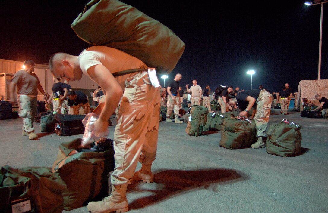 Shortly after his arrival in Southwest Asia Sept. 17, Airman 1st Class Jeffery Madden removes items he'll need for a 36-hour layover before taking his personal baggage through a customs inspection. Airman Madden is a civil engineer assistant from Fairchild Air Force Base, Wash. (U.S. Air Force photo/Master Sgt. Scott Wagers)