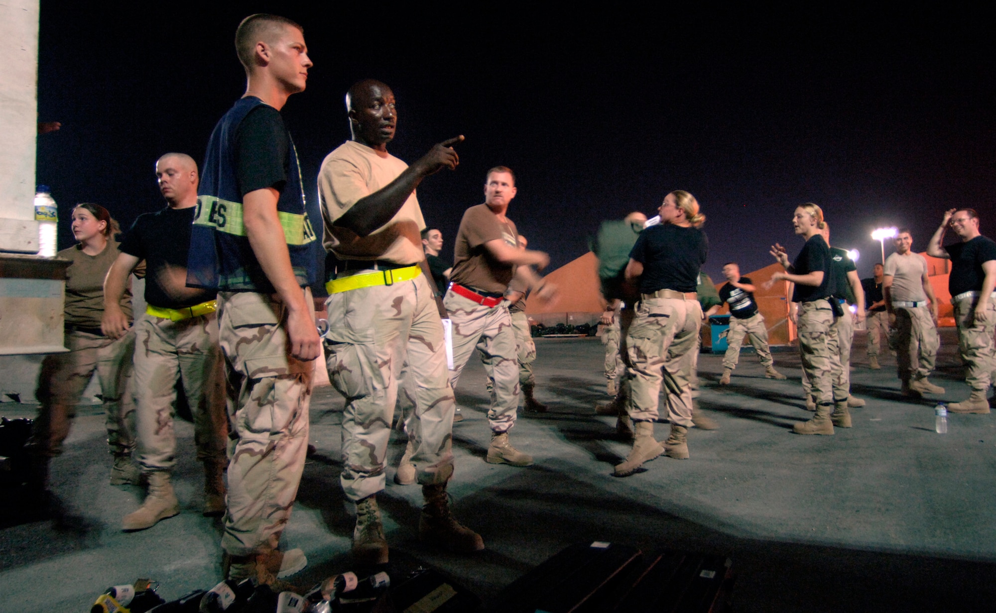 While newly arrived servicemembers unload luggage from a commercial DC-10 airliner in Southwest Asia Sept. 17, Tech. Sgt. Lonnie Coleman gives on-the-job-training to Tech. Sgt. Ben Davis who will serve as his replacement for the next deployment rotation. (U.S. Air Force photo/Master Sgt. Scott Wagers) 
