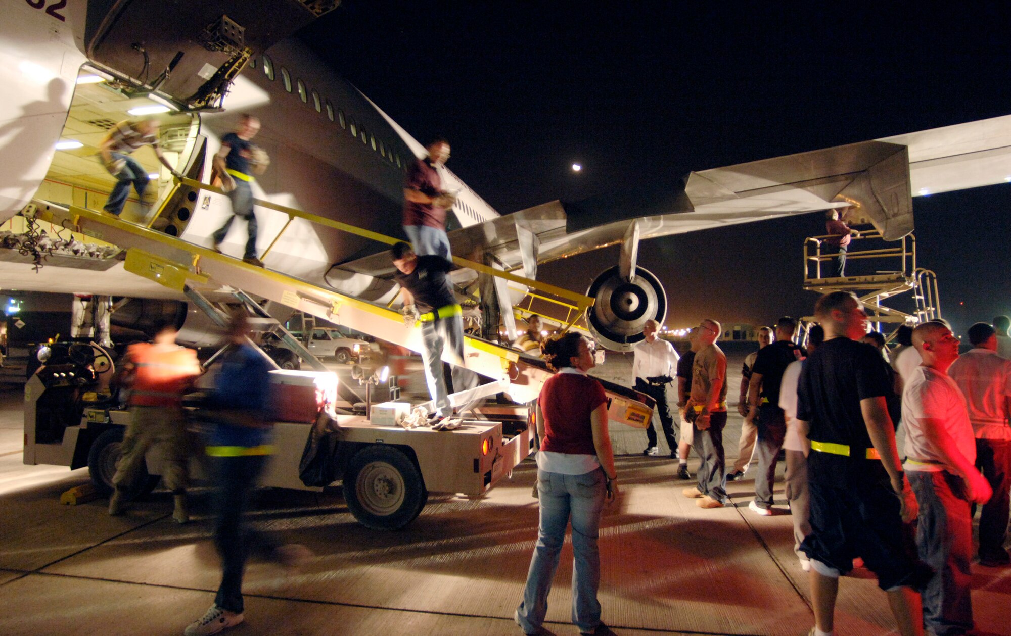 Minutes after landing in Southwest Asia following a 24-plus hour flight, a volunteer detail of 30 volunteers assists ground crews in removing luggage from the cargo hull of a commercial DC-10 airliner Sept. 17. (U.S. Air Force photo/Master Sgt. Scott Wagers) 
