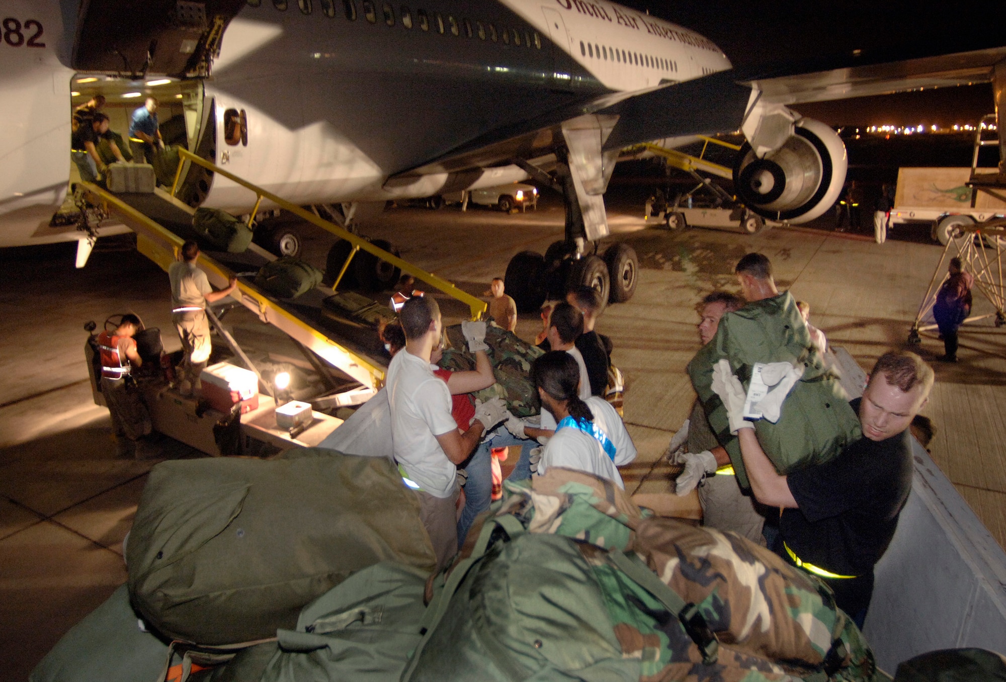 Minutes after landing in Southwest Asia, Senior Airman Matt Eggleston joins 30 other volunteer passengers Sept. 17 in removing luggage from the cargo hull of a commercial DC-10 airliner. (U.S. Air Force photo/Master Sgt. Scott Wagers)
