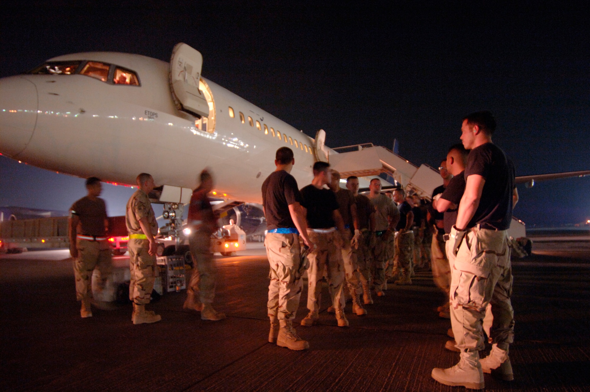 Minutes after landing on the ground in Southwest Asia, a volunteer detail of 30 passengers receives instructions Sept. 17 on how to assist local ground crews in removing luggage from the cargo hull of the commercial DC-10 they just flew in on. (U.S. Air Force photo/Master Sgt. Scott Wagers) 

