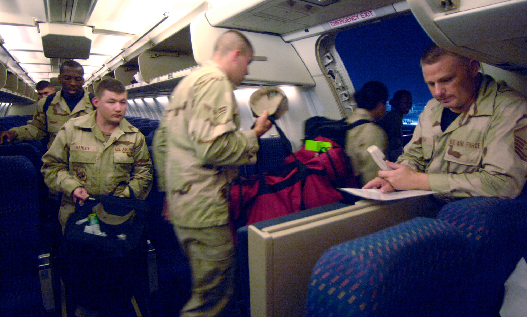 Minutes after landing in Southwest Asia after a 24-plus hour flight from the United States, Master Sgt. Eric Gadow asks for 30 volunteers to assist ground crews in removing luggage from the cargo hull of a commercial DC-10 airliner Sept. 17. Limited flightline personnel and the average influx of nearly 35,000 servicemembers at peak deployment rotation requires the involvement of passengers in moving personal baggage. (U.S. Air Force photo/Master Sgt. Scott Wagers)

