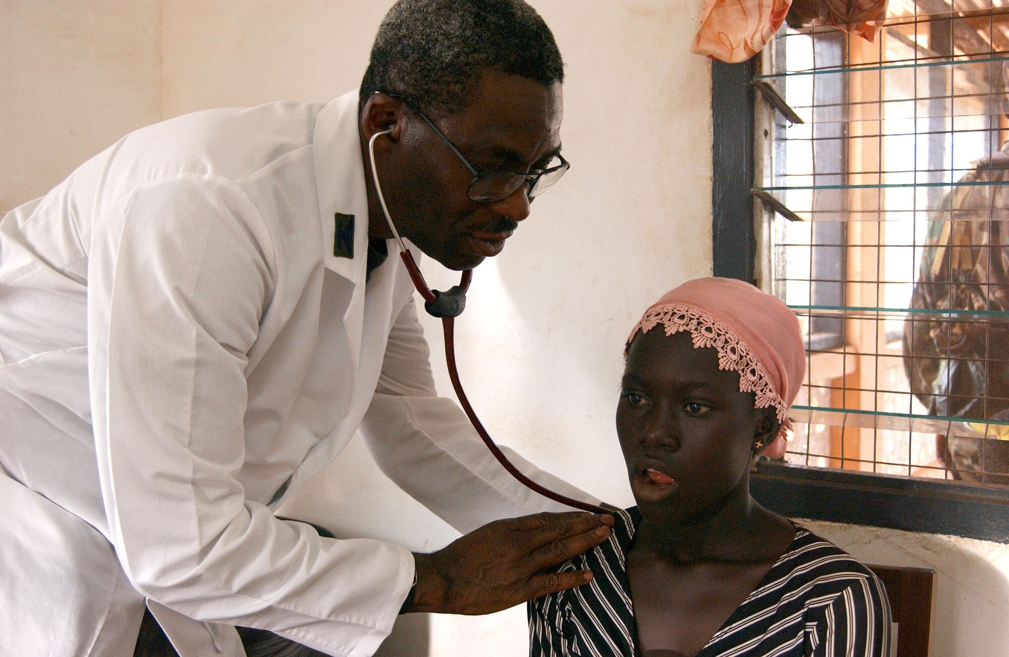 Col. Victor Folarin, 52nd Aerospace Medicine Squadron commander, Spangdahlem AB, Germany, treats a patient during Med Flag 2006.  The colonel is a native of Lagos, Nigeria and was tasked as the mission commander for Med Flag 2006 in Ghana.