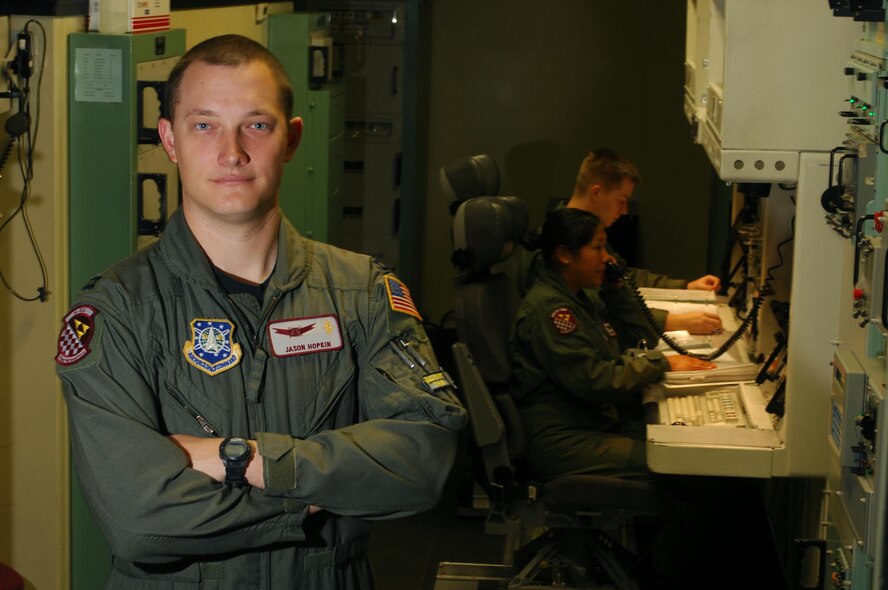 Captain Jason Hopkin observes two missile combat crew members training in a missile procedures trainer Sept. 18 at Minot Air Force Base, N.D.  Captain Hopkin is space and missiles operator instructor with the 91st Operations Support Squadron.  He and the 260 missile combat crew members stationed at Minot will celebrate the 59th Anniversary of the Air Force by standing alert in the 15 Missile Alert Facilities throughout the 8500 square mile North Dakota missile complex.  (U.S. Air Force photo/Staff Sgt. Joe Laws)