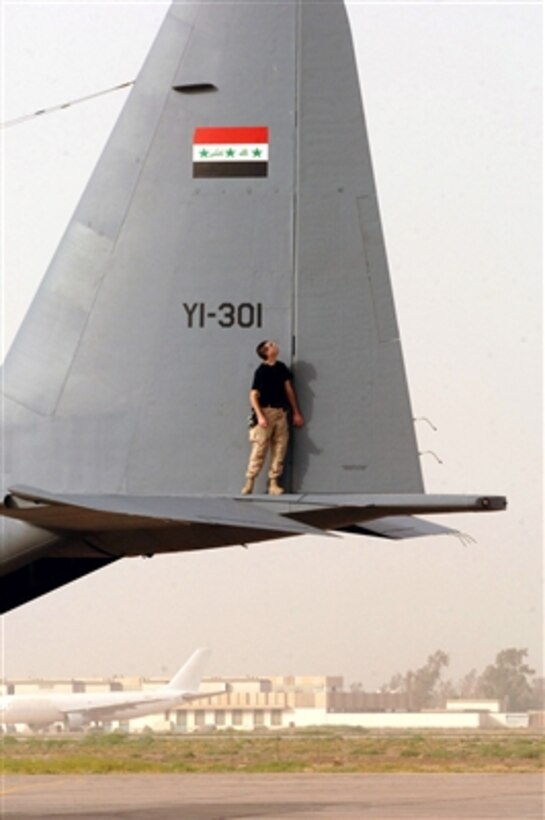 U.S. Air Force Senior Airman Jeff McCain performs a post-flight check on an Iraqi air force C-130 Hercules aircraft at New Al Muthana Air Base, Iraq, on July 11, 2006.  McCain is assigned to the Coalition Air Force Transition Team working with Iraqis to rebuild their air force.  
