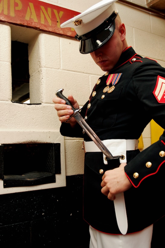 MARINE BARRACKS WASHINGTON ? Sgt. Jeff Kopp, a 22-year-old Clinton, Iowa native, removes an ?Irish pennant? from his uniform during a gear inspection. Kopp also looks over his uniform prior to each drill practice session.