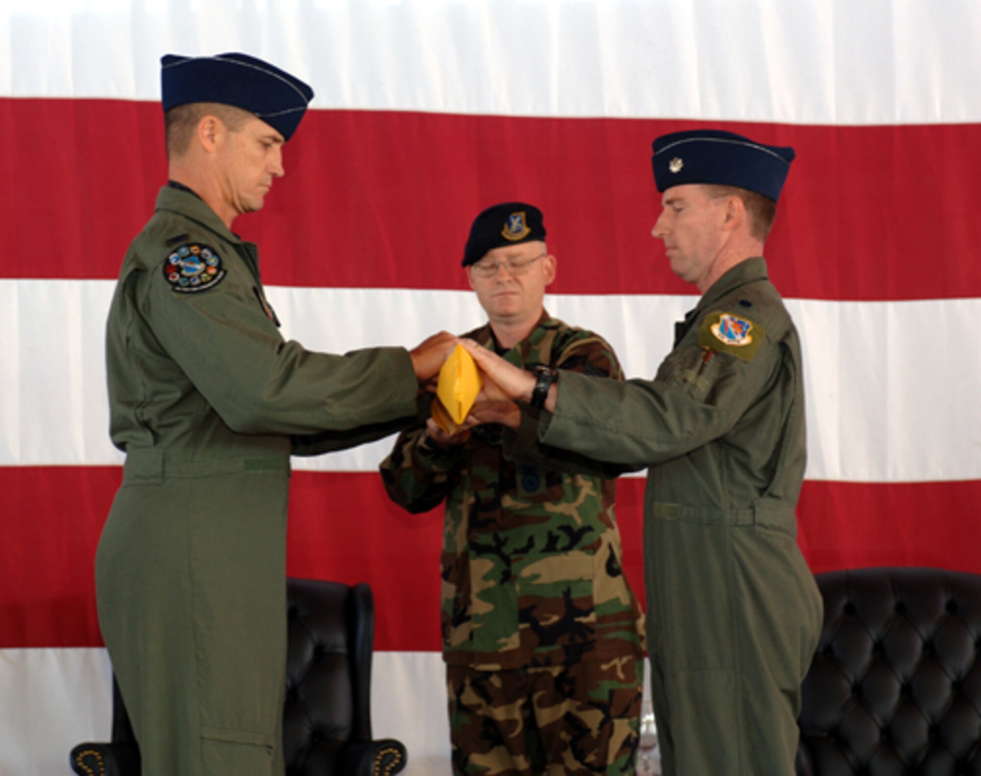 Col. Gregory Neubeck, 53rd Test Evaluation Group commander and Lt. Col. Rick Silong, Detachment 1 commander, wrap up the detachment's guidon in preparation for its retirement during the Sept. 15 ceremony. (Amn. John Strong)
