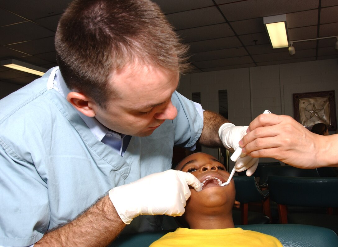 Capt. Nathan Krivitzky examines the teeth of Ross Chandler Sept. 13 at Lackland Air Force Base, Texas. Captain Krivitzky is a Pediatric Dental Course resident from Aviano Air Base, Italy. Ross is the son of Senior Airman Cabrille Chandler, a 59th Medical Wing Support Squadron referral clerk.  (U.S. Air Force photo/Master Sgt. Kimberly Yearyean-Siers)
