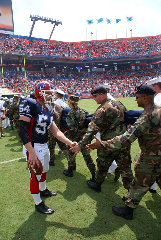 Military members from around South Florida received deafening applause from a packed stadium during opening ceremonies of the Miami Dolphins first home game Sep. 17. As they left the field, Buffalo Bills long snapper Mike Schneck stepped off the sidelines to thank the troops, such as Staff Sgt. Stuart Garner, 482nd Security Forces, Homestead Air Reserve Base. (Air Force Photo by Dan Galindo) 