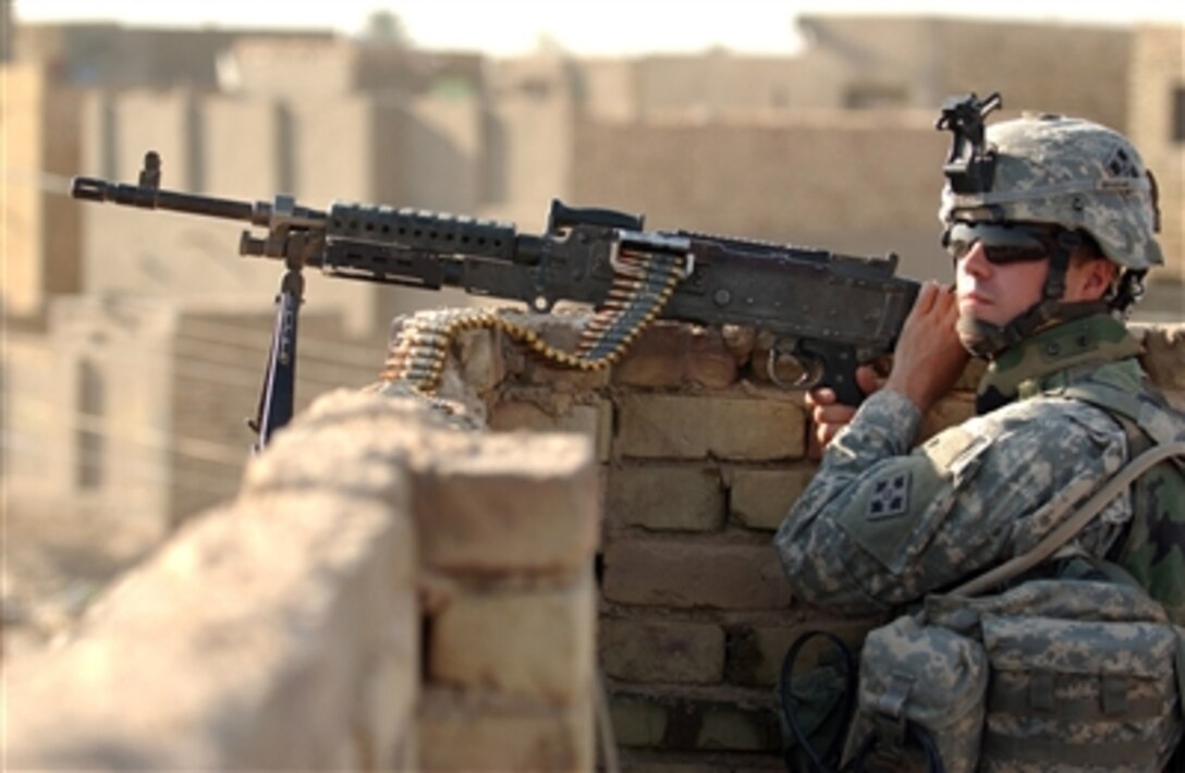 Army Spc. Eric Leon mans an M-240B machine gun as he provides security for his fellow soldiers as they conduct a cordon and search operation with Iraqi army soldiers in Diwaniyah, Iraq, on Sept. 16, 2006.  Leon is with 1st Platoon, Alpha Company, 1st Battalion, 8th Infantry Regiment, 2nd Brigade Combat Team.   