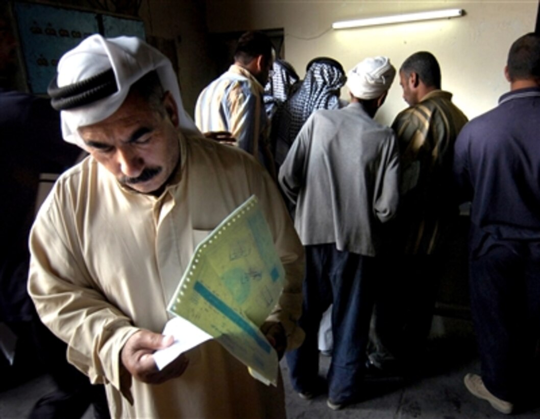 An Iraqi merchant from Tarmiya, Iraq, checks his paperwork at a food rations warehouse in Baghdad, Iraq, Sept. 16, 2006. The group of Tarmiyan merchants loaded their trucks with tea, sugar, baby formula, and cooking oil.