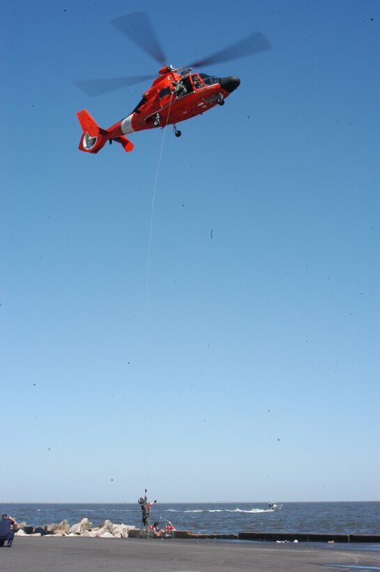 United States Coast Guardsmen prepare to life a victim to the helicopter during Operation Lily Pad Sept. 20.  The exercise was designed to simulate a hurricane with sever flooding conditions.