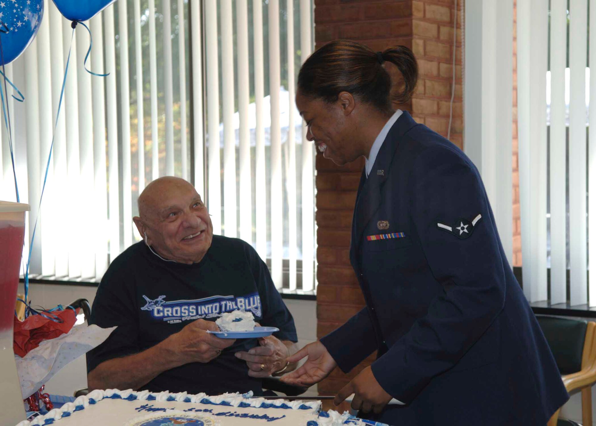 Airman Melissa Drake hands a piece of cake to retired Tech. Sgt. Cloid Sowell at the Charlotte Hall Veterans Home in Charlotte Hall, Md., Sept. 18.  The Airman and the veteran participated in the cake-cutting as the youngest Airman and oldest Air Force veteran there. Airman Drake is assigned to the 89th Communications Squadron at Andrews Air Force Base, Md. (U.S. Air Force photo/Airman 1st Class Laura N. Cirksena)