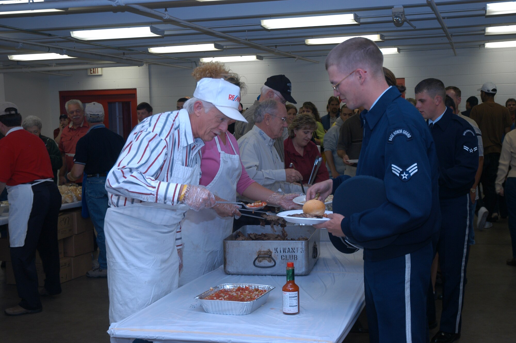 David Nahrgang, a volunteer with the Military Affairs Committee of the Cheyenne Chamber of Commerce, serves Senior Airman Jerrod Biddle, 90th Maintenance Operations Squadron, during the Santa Maria Barbecue in Cheyenne, Wyo., on Sept. 20. (U.S. Air Force photo by 1st Lieutenant Josh Edwards) 

