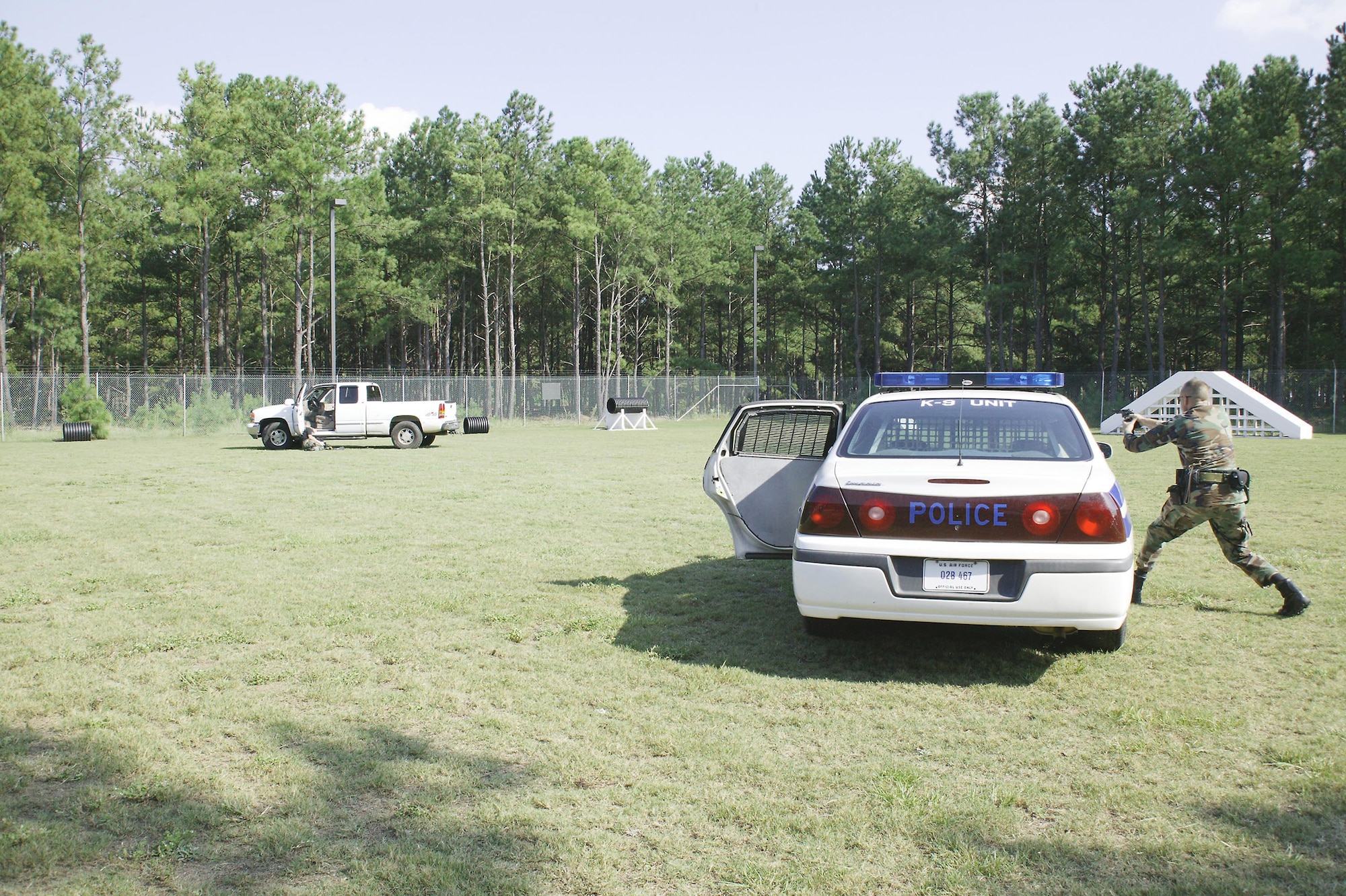 Tech. Sgt. Arthur Sawyer, 20th Security Forces Squadron military working dog handler, “shoots” Staff. Sgt. Bradley Lehman, 20th SFS MWD handler, in a police chase scenario during a demonstration for more than 80 JROTC cadets. The cadets visited the base from Grafton, Ohio, where they learned about the duties of a MWD handler.  (U.S. Air Force photo/Senior Airman Holly MacDonald)