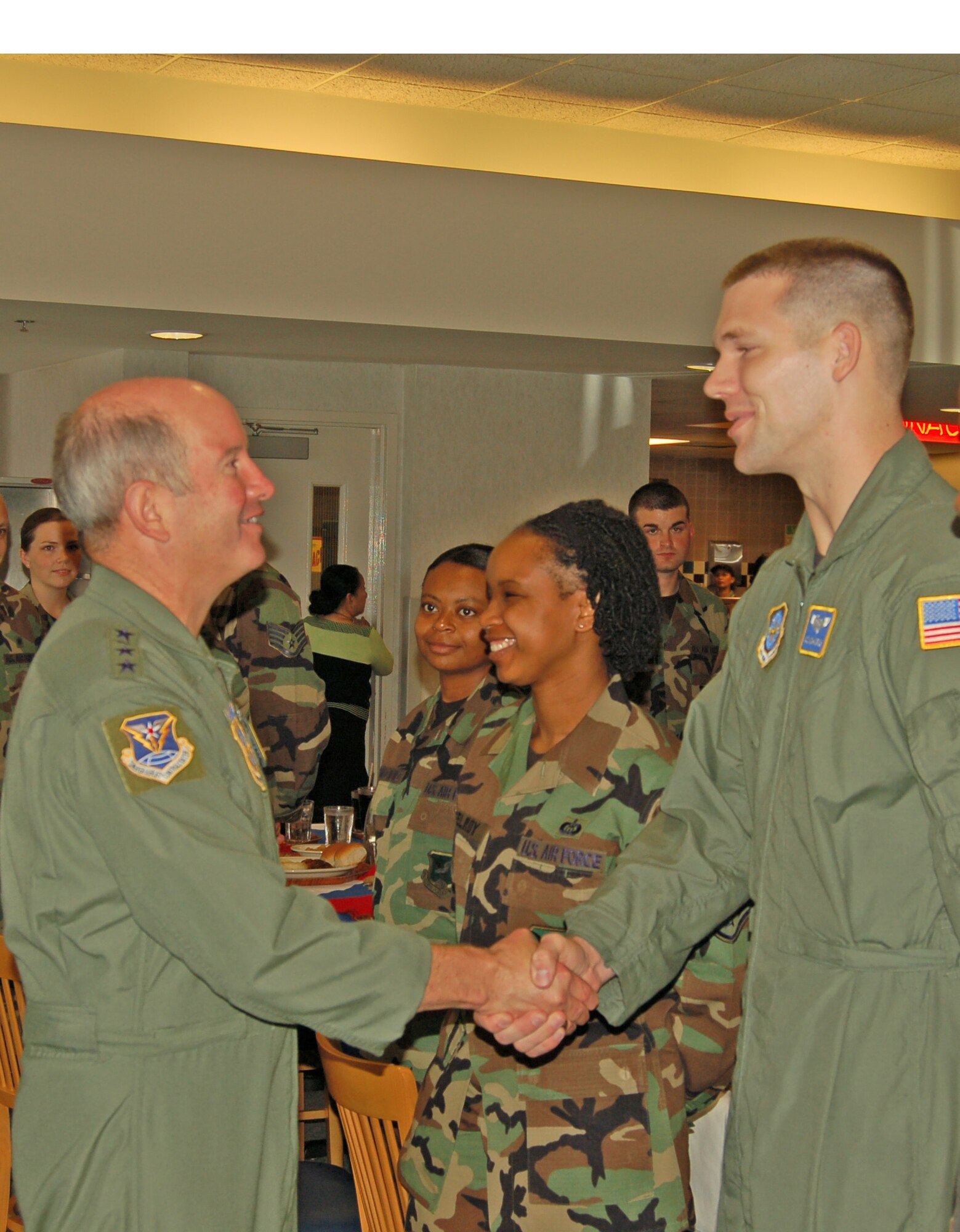 Gen. Duncan McNabb, Air Mobility Command commander, greets Airman 1st Class Michael Irish,  9th Airlift Squadron loadmaster, during the general's luncheon with 436th Airlift Wing Airmen at the Patterson Dining Facility Monday. (U.S. Air Force photo/Staff Sgt. James Wilkinson)