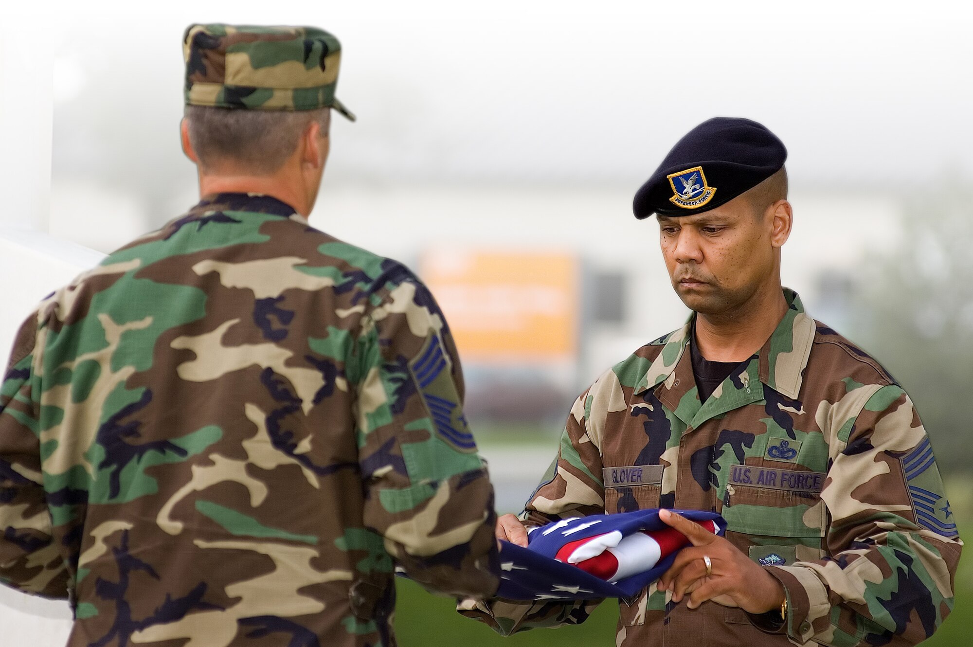 Chief Master Sgt. James Glover (right), 436th Security Forces Squadron, and Chief Master Sgt. Timothy Reuning, 436th Operations Support Squadron, fold the American flag during the POW/MIA retreat ceremony Sept. 15 at the base flagpole. (U.S. Air Force photo/Roland Balik)
