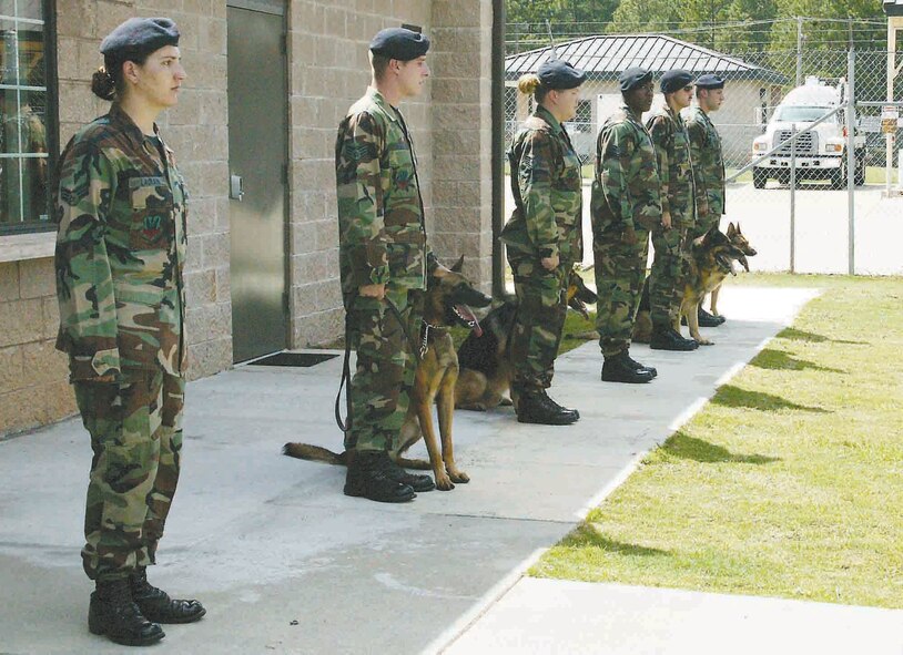 SHAW AIR FORCE BASE, S.C.-- Senior Airman Aymee Laurain (left), 20th Security Forces Squadron dog handler, stands alone in remembrance of military working dog Rex who died of cancer Sept. 12. (U.S. Air Force photo/Tarsha Storey)