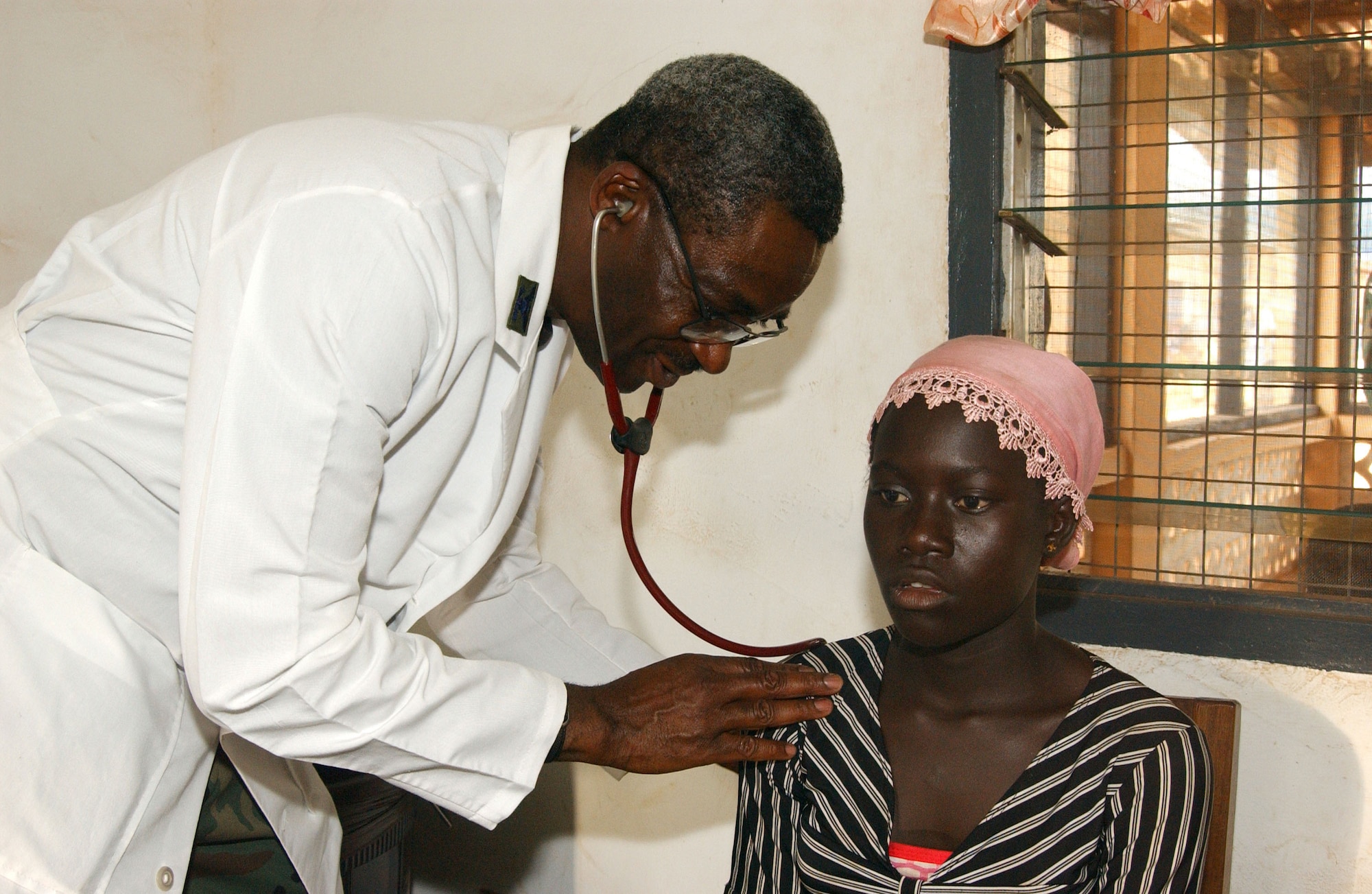 Col. (Dr.) Victor Folarin does an initial assessment on a Ghanaian woman complaining of chest pains during Med Flag 2006 in Tamale, Ghana, Sept. 15. Colonel Folarin, a native of Lagos, Nigeria, made his first trip back to his homeland since 1992 as the exercise commander. Colonel Folarin is the 52nd Medical Group flight surgeon and commander from Spangdahlem AB. (U.S. Air Force photo/Tech. Sgt. Pamela Anderson)