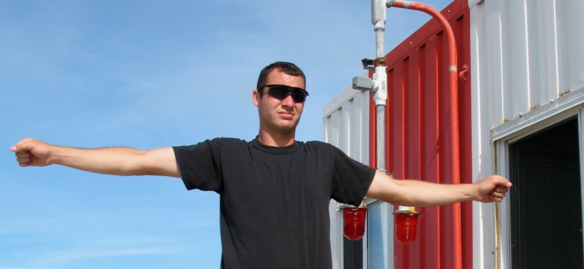 Staff Sgt. Brian Kaufman gives hand signals as he watches the nylon straps of an aircraft arrest system release at Wake Island Sept. 20. Sergeant Kaufman is assigned to the 15th Civil Engineer Squadron. (U.S. Air Force photo/Tech. Sgt. Chris Vadnais)
