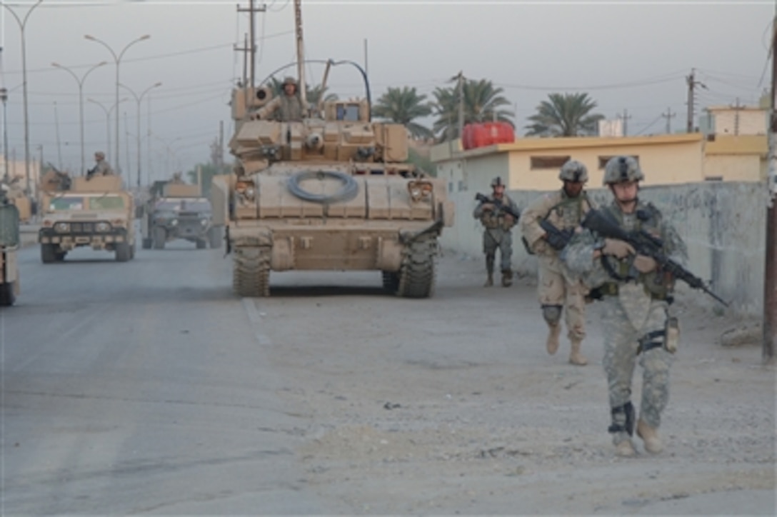 U.S. Army soldiers of 1st Battalion, 67th Armored Regiment, provide security for Iraqi army soldiers from the 8th Iraqi Army Division during house searches in Diwaniwah, Iraq, on Sept. 16, 2006.  
