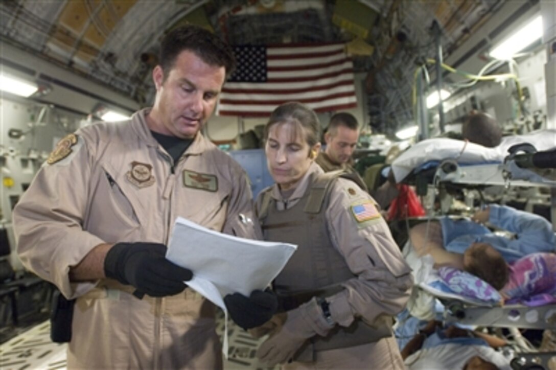 Air Force Tech. Sgt. Scott Drake (left) and Maj. Jacqueline Deeds check the paperwork as they prepare patients for an aeromedical evacuation flight aboard a C-17 Globemaster III aircraft at Balad Air Base, Iraq, on Sept. 14, 2006.  Drake, the lead medical technician, and Deeds, the medical crew director, are both with the 791st Expeditionary Aeromedical Evacuation Squadron.  