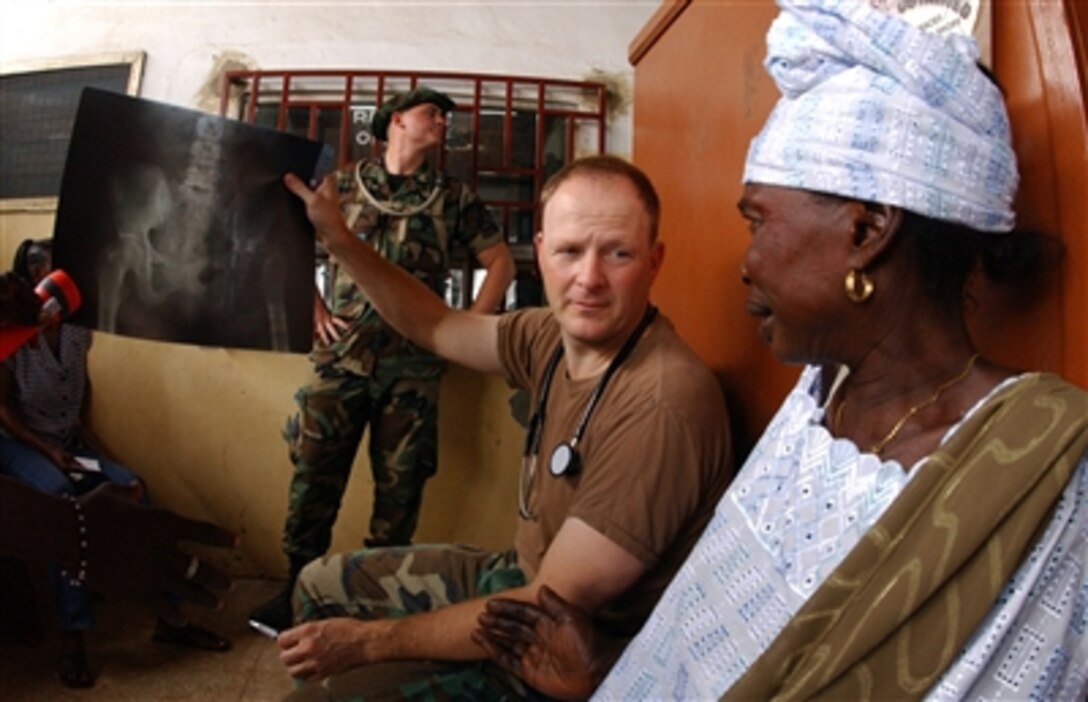 U.S. Air Force Lt. Col. Bryan DeLage reviews X-rays with a patient during MEDFLAG 2006 at the Mallam-Atta Market Government Clinic in Accra, Ghana, Sept. 13, 2006. Medical personnel from U.S. Air Forces in Europe are treating residents and training local health care workers during this medical-training exercise.