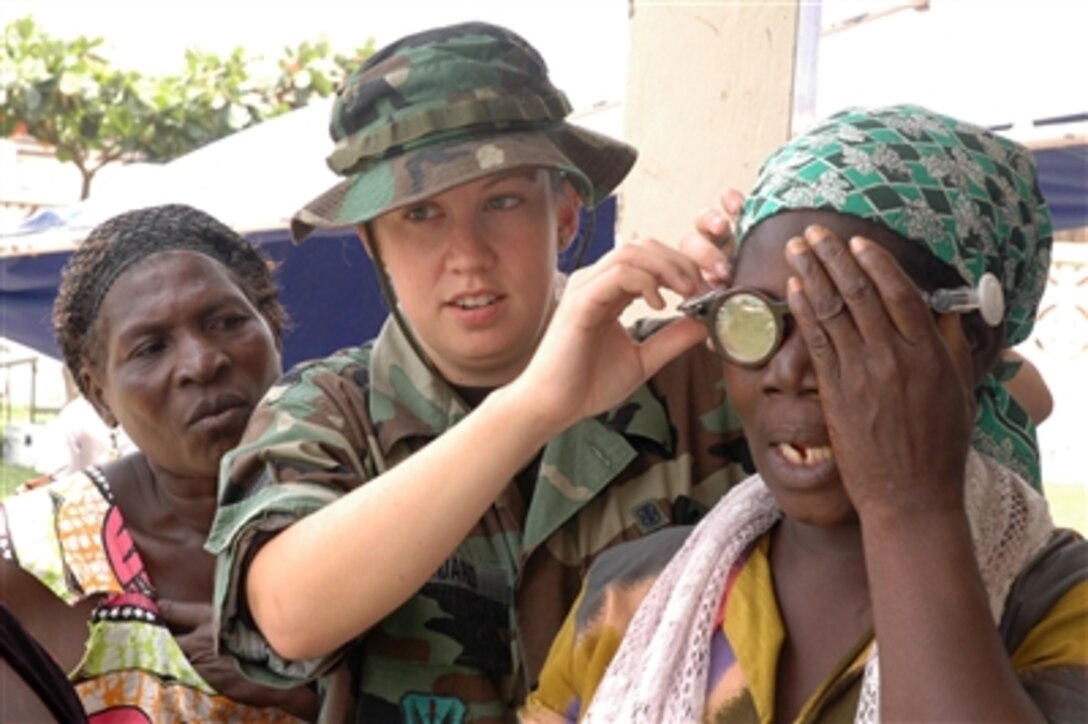 Staff Sgt. Melissa Woodard fits a patient with self-adjusting prescription eyewear at the Nima Governmental Clinic in Accra, Ghana, on Sept. 11, 2006, during MEDFLAG 2006.  MEDFLAG 2006 is a joint medical-training exercise where medical personnel from U.S. Air Forces in Europe are treating residents and training local health care workers. Woodard is assigned to the Air Forceís 119th Medical Group.  
