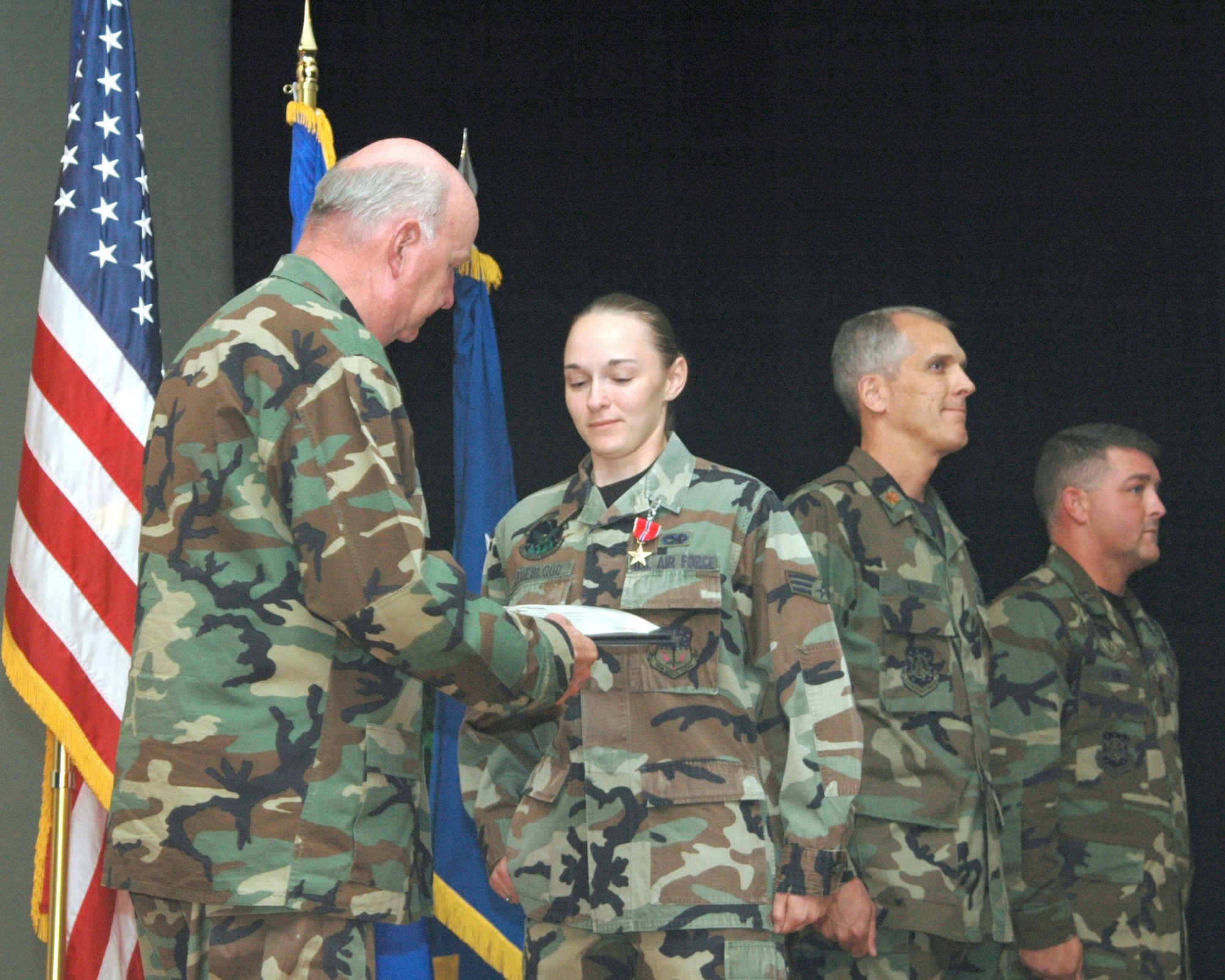 Maj. Gen. Thomas F. Deppe, 20th Air Force commander, presents Senior Airman Charity Trueblood, 341st Logistics Readiness Squadron, with the citation to accompany the Bronze Star Medal with Valor she received Sept. 14 for duties performed in support of the Global War on Terrorism. (U.S. Air Force photo by Airman Emerald Ralston)