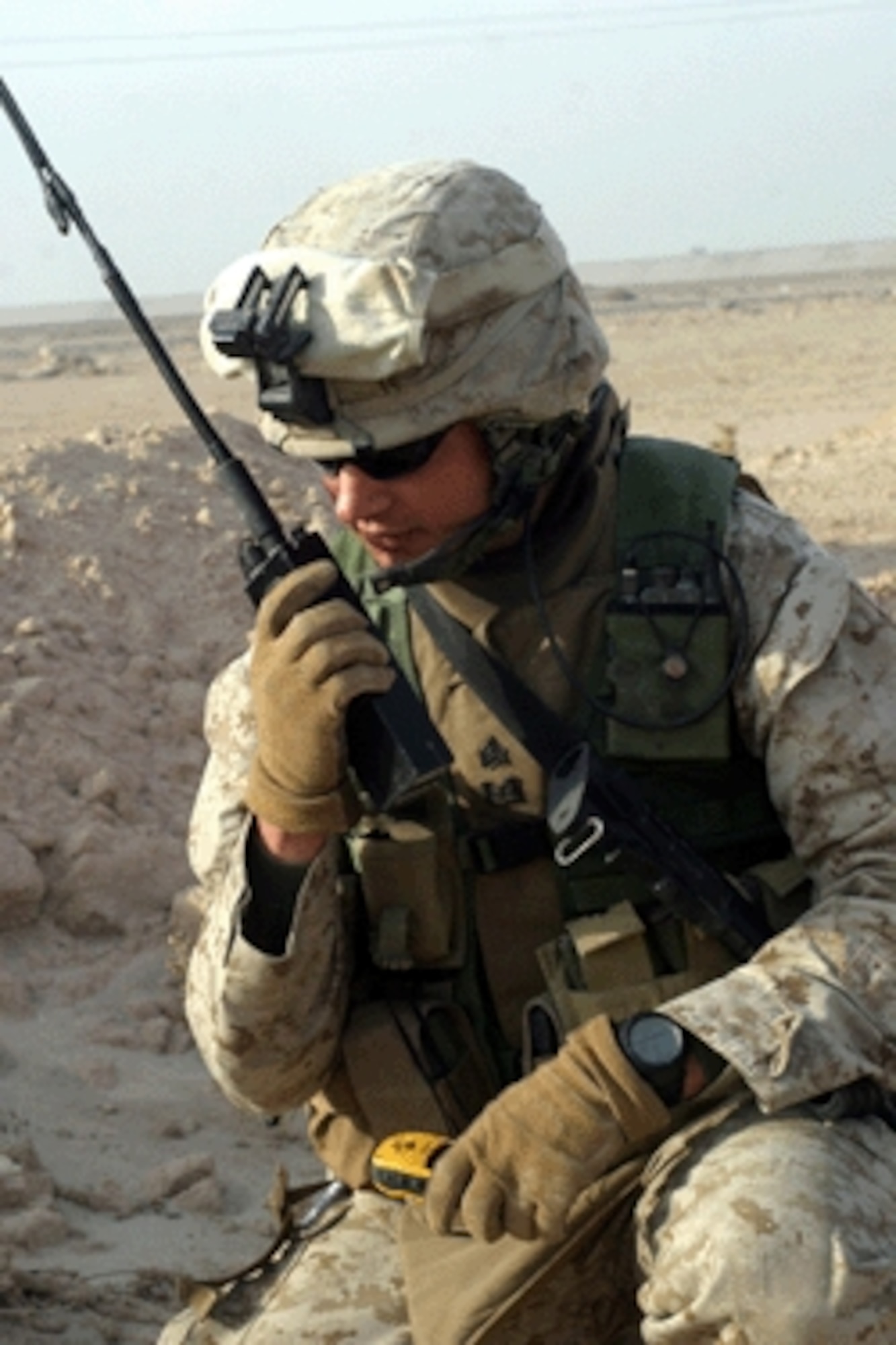 KHARMA, Iraq — Marine Sgt. Brandon Shofne radios back to his headquarters descriptions of the ordnance found during a weapon cache sweep in Kharma, Iraq, last December. Sergeant Shofne, who is attached to the USMC's 2nd Combat Engineers Battalion, is using a legacy radio. The JTRS radios recently purchased by the ESC team will provide upgraded capability.  (DoD photo by Lance Cpl. Matthew Hutchison, U.S. Marine Corps)

