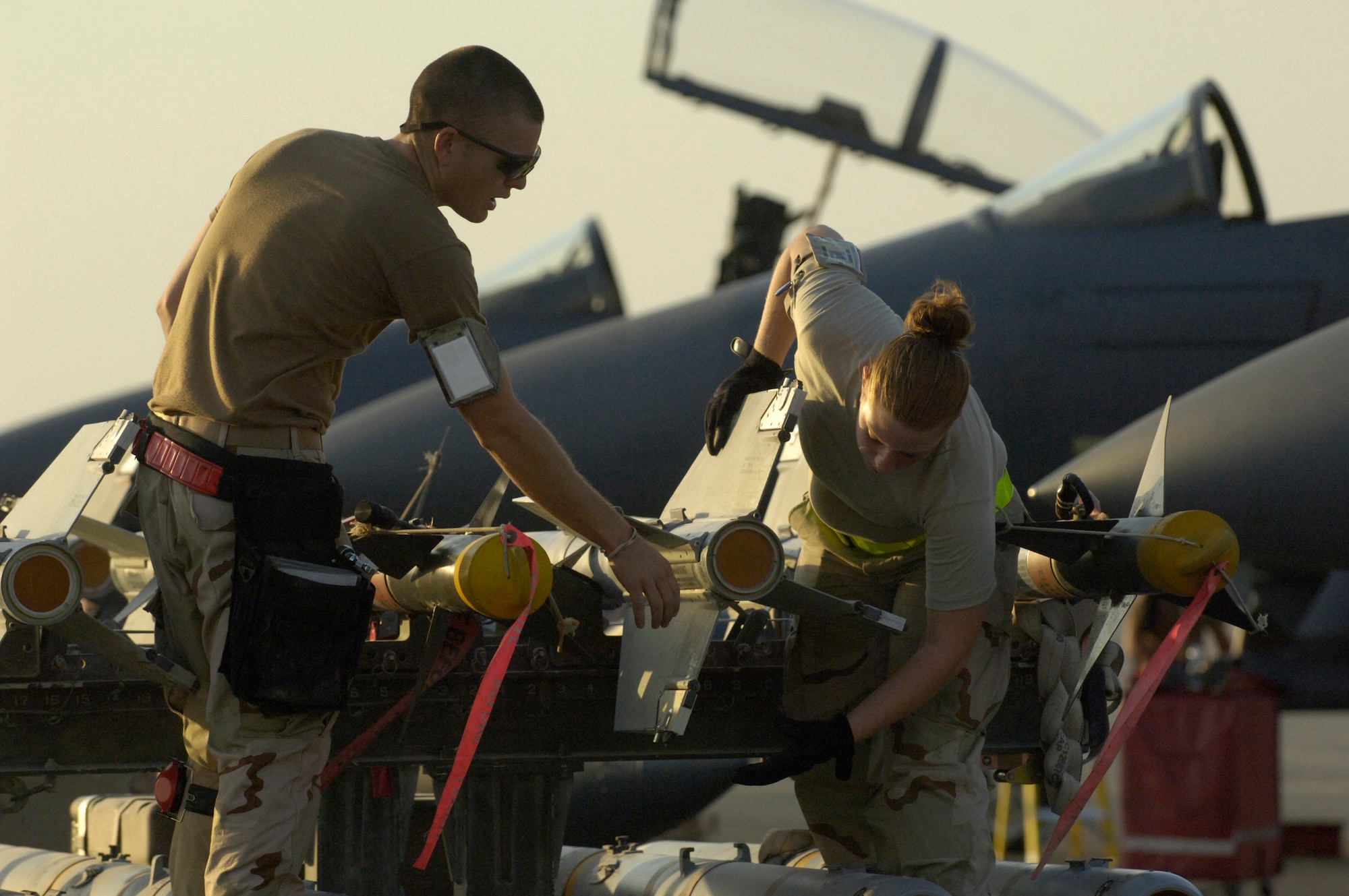 Staff Sgt. Kevin Harvey and Airman 1st Class Amanda Hicks prepare to load M-120 and AIM-9 rockets on one of six F-15E Strike Eagles that landed at a forward-deployed base in Southwest Asia Sept. 21. Sergeant Harvey and Airman Hicks are weapons loaders assigned to the 494th Aircraft Maintenance Unit. The aircraft are from Royal Air Force Lakenheath, England. (U.S. Air Force photo/Master Sgt. Scott Wagers)