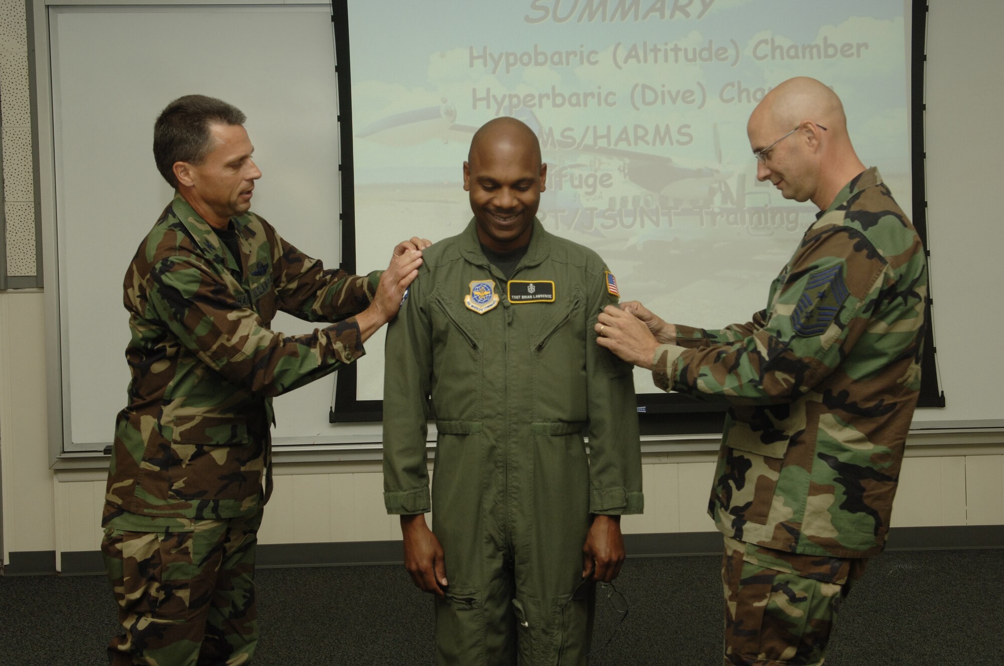 FAIRCHILD AIR FORCE BASE, Wash. - Colonel Scott Hanson, 92nd Air Refueling Wing commander, and Chief Master Sgt. Mark Luzader, 92nd ARW command chief, attach master sergeant stripes to Brian Lawrence, 92nd Aeromedical Dental Squadron NCO in change of aerospace physiology training flight operations. (U.S. Air Force photo/Senior Airman Chad Watkins)