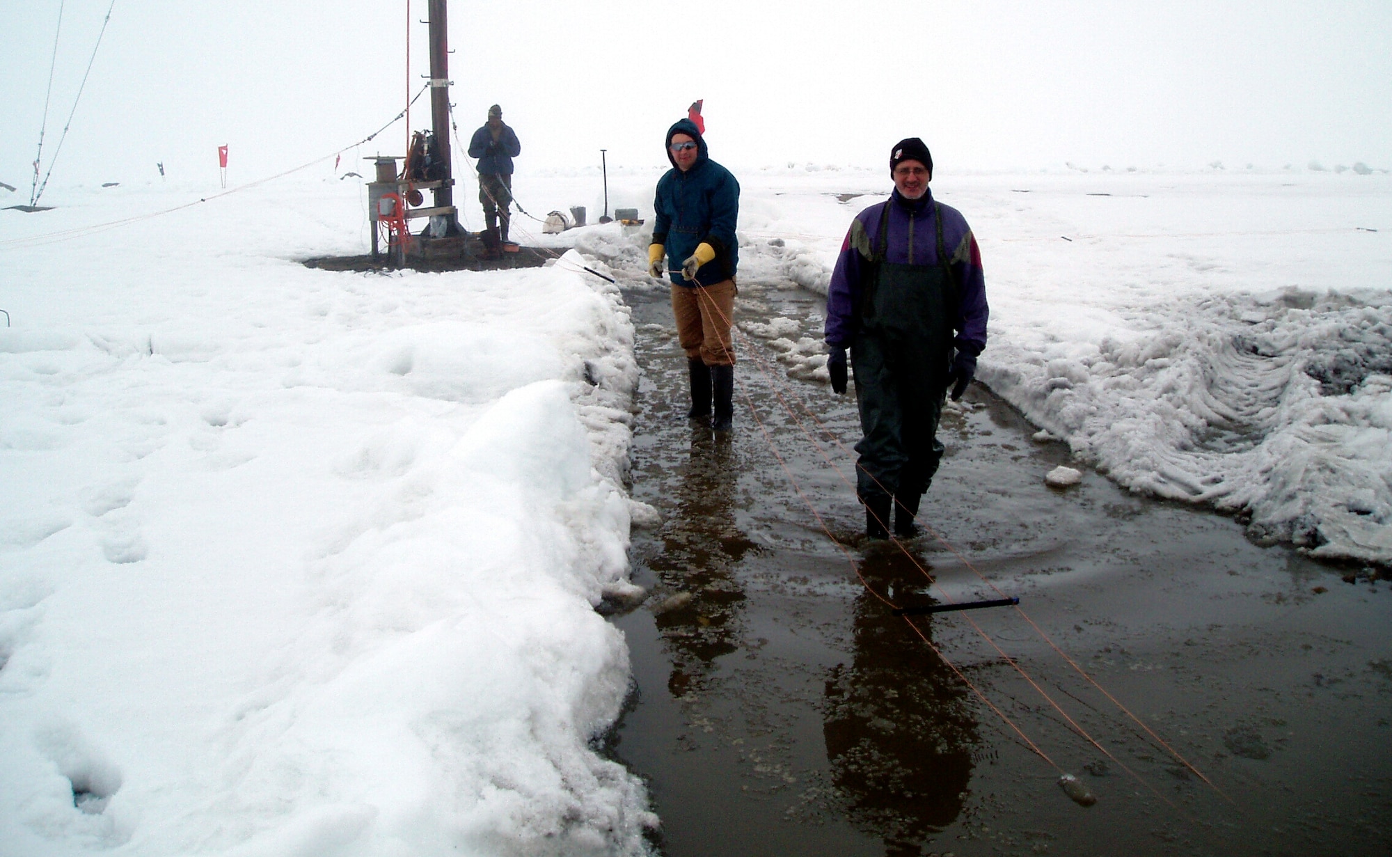 Second Lt. Isseyas Mengistu (rear), 1st Lt. Robert Esposito (middle) and Jake Quinn, lay out ionosonde antenna elements on the frozen tundra at Station Nord, Greenland, prior to hoisting them up an 82-foot pole. The men, researchers with the Air Force Research Laboratory's Space Vehicles Directorate, are part of a team working to improve the capability to predict ionosphere-created disturbances in the atmosphere. (U.S. Air Force photo)