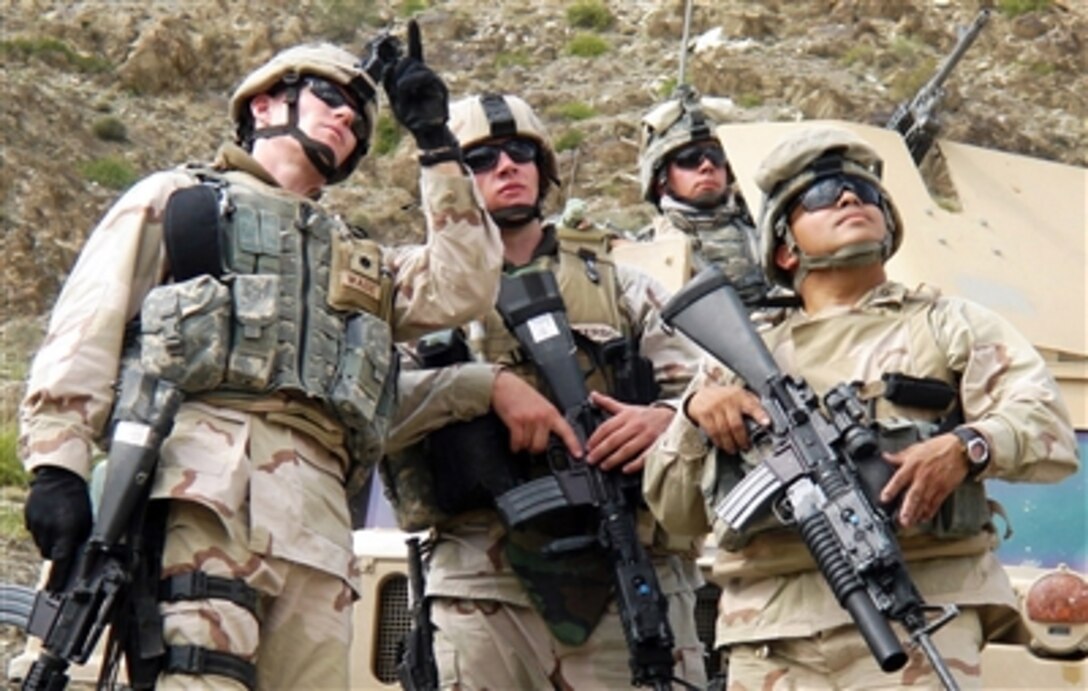 From left: U.S. Navy Cmdr. John Wade, Petty Officer 3rd Class Karl Graham, Petty Officer 2nd Class David Mellor and Petty Officer 1st Class David Umana, look to the sky as aircraft provide combat air support during Operation Mountain Fury in Afghanistan, Sept. 19, 2006.  