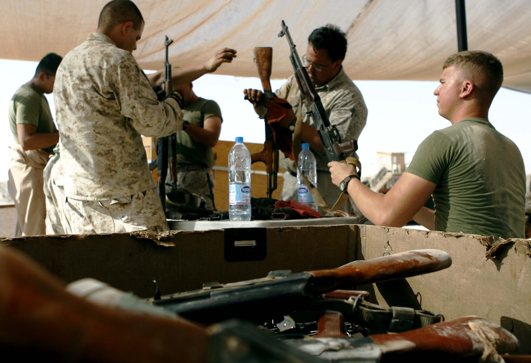 A team of Marines and civilians inspect recovered Iraqi weapons before redeploying them to the Iraqi Army. The team is part of Ammunition Platoon, Supply Company, Combat Logistics Regiment-15, 1st Marine Logistics Group (Forward), and has assumed these duties on top of their usual daily workload. ?We need to arm our allies,? said Warrant Officer Robert P. Smith, officer in charge of Camp Taqaddum?s Ammunition Supply Point. ?We not only need to train them on our tactics, we need to arm them with what they need to fight the insurgents.? Camp Taqaddum is not the only base contributing to the redeployment of seized weapons. The Marine Corps has also established collection points at Al Asad and Fallujah.