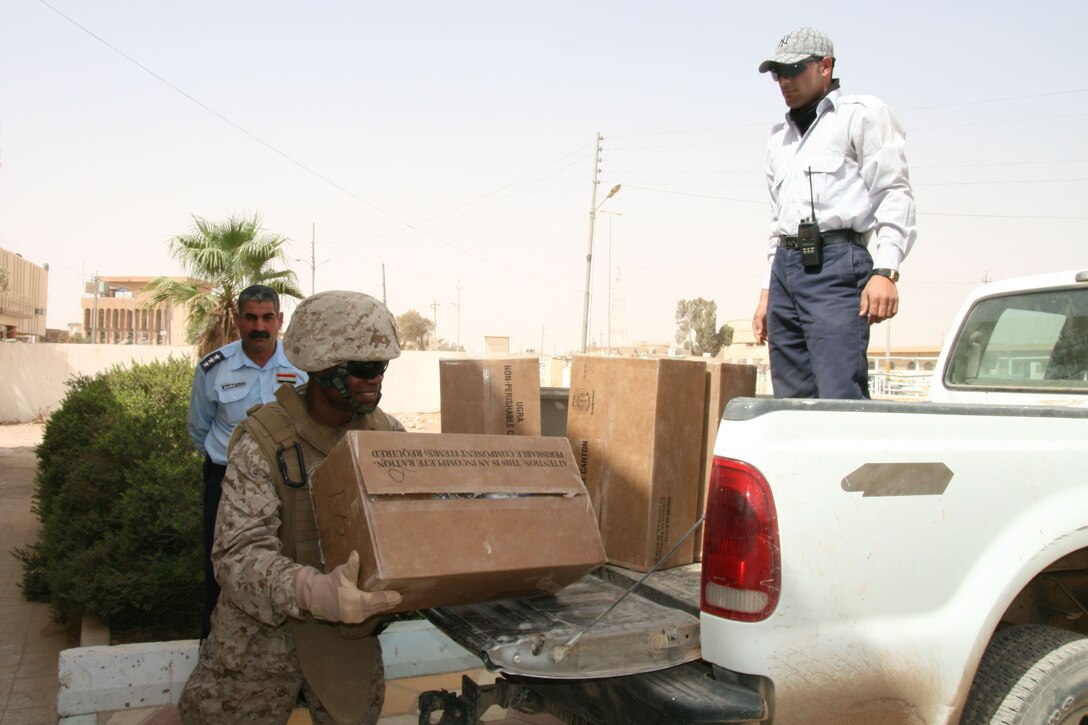 Navy Chaplain Lt. Cdr. Kobena Arthur unloads a box of food at the city council building in Rutbah, Iraq.  The Marines and sailors of 2nd Light Armored Reconnaissance Battalion and 2nd Battalion, 25th Marine Regiment delivered about 60 boxes of non-perishable food, as well as bags of milk, juice fresh fruit and other items to less-fortunate families in Rutbah, Sept. 24, 2008.  Arthur took over management of the program in September and has worked to transform it into a full-fledged non-governmental organization comprised of local Iraqi women.