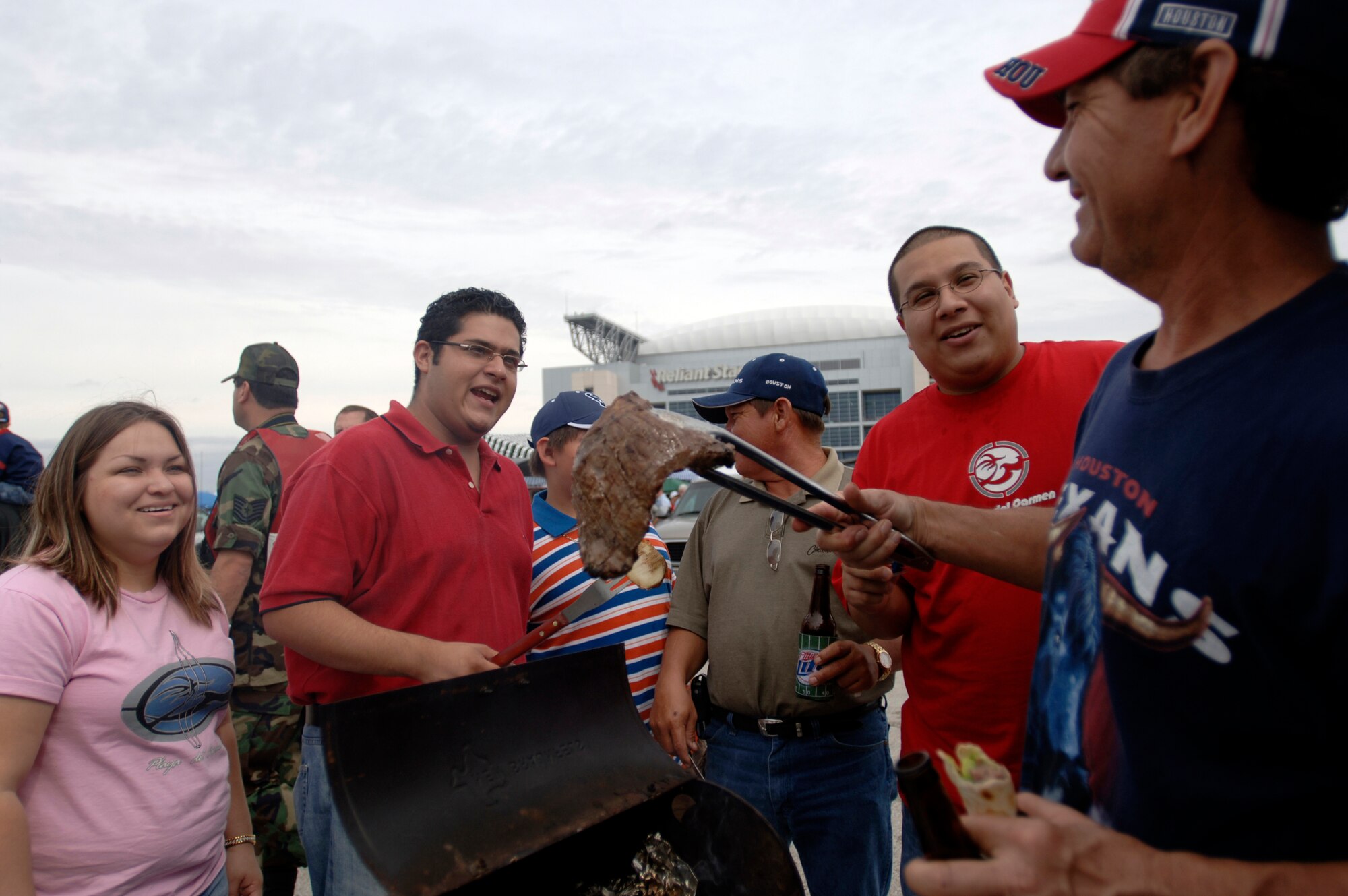 Houston Texans fans Flor Cruz, Joe Sanchez, Jaudiny Cuellar and Dr. Beto Esquibel barbecue some ribeye steaks during their tailgate party in the parking lot of Reliant Stadium in Houston Sept. 24. The game between the Houston Texans and Washington Redskins was designated as the Houston Texan's Salute to the Military day by team officials. (U. S. Air Force photos/Tech Sgt. Cecilio M. Ricardo)