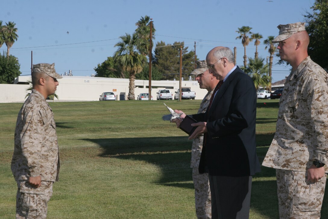 Retired Army Maj. Gen. Robert Shadley presents Staff Sgt. Eric Azevedo, 1st Tank Battalion, the Best of the Best Award at the Combat Center Parade Field Sept. 25.