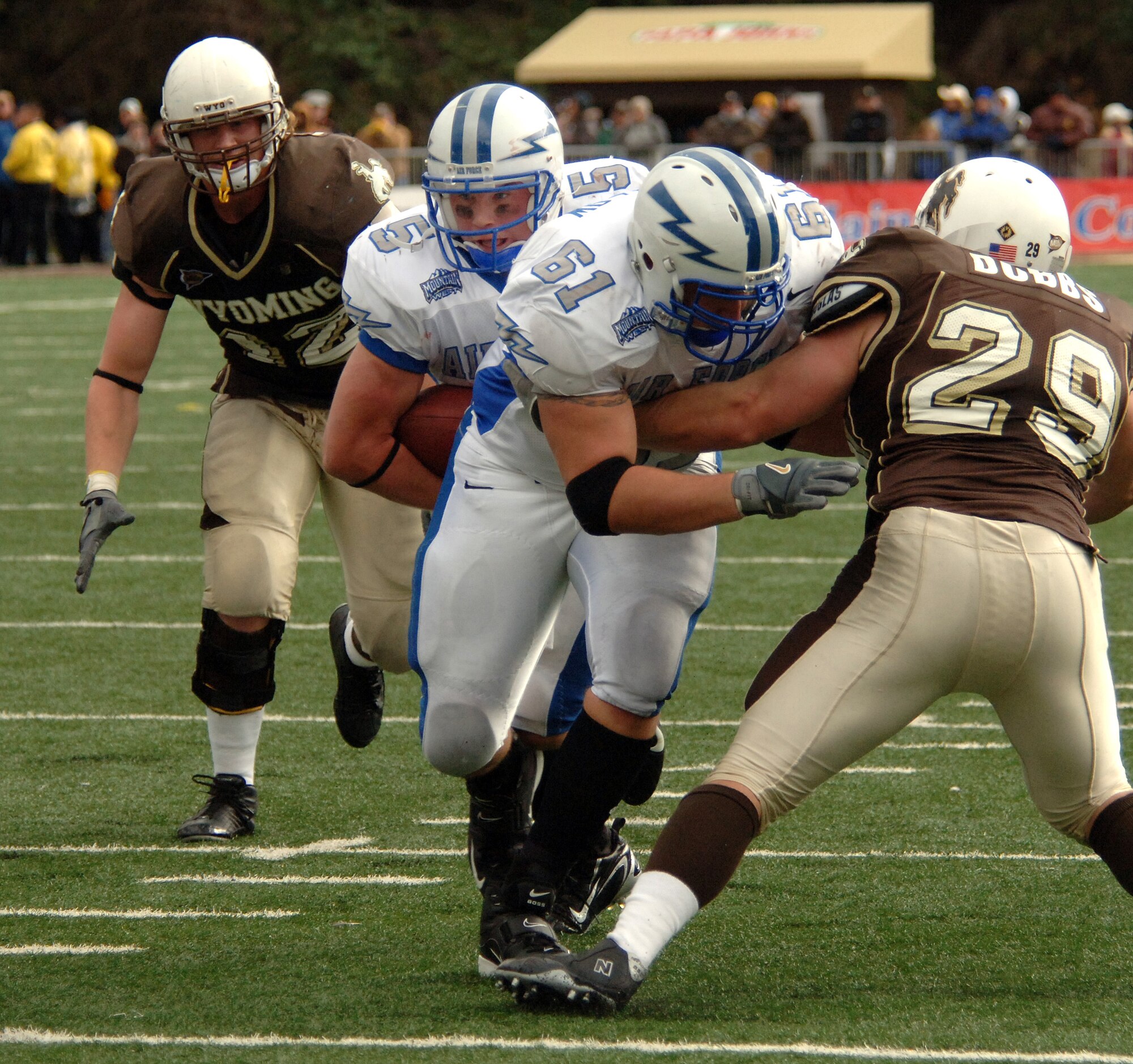 Falcons left tackle Tyler Dolhallow (#61) plows a path through Wyoming middle linebacker Ward Dobbs so Falcon quarterback Shaun Carney (#5) can gain yardage up the middle. Carney carried 25 times for 131 yards and two touchdowns during the Falcons' 31-24 win over Wyoming Sept. 23. The Falcons improve their record to 1-1 with this conference win, and will continue Mountain West Conference action Sept. 30 when they battle New Mexico at Falcon Stadium. (U.S. Air Force photo/John Van Winkle)