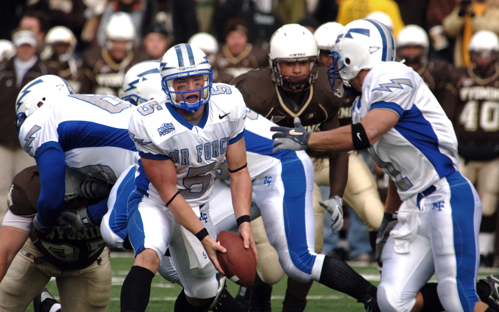 Falcons quarterback Shaun Carney pitches to halfback Chad Hall.  The Falcons' triple-option rushing attack anchored a running game that had 70 carries for 327 yards against Wyoming Sept. 23. Air Force won their Mountain West Conference opener 31-24, and next faces New Mexico Sept. 30 at Falcon Stadium. (U.S. Air Force photo/John Van Winkle) 