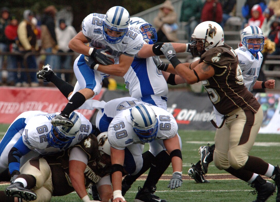 Falcon halfback Beau Suder goes airborne for yardage over the blocks of right guard Curtis Grantham (#62) and center Stuart Perlow (#60) as left guard Tyle Dohallow fends off Wyoming defensive tackle Corey Mace. The four Air Force senior starters combined for a first down on this play.  Air Force improved its record to 1-1 with a 31-24 win over Wyoming. (U.S. Air Force photo/John Van Winkle) 