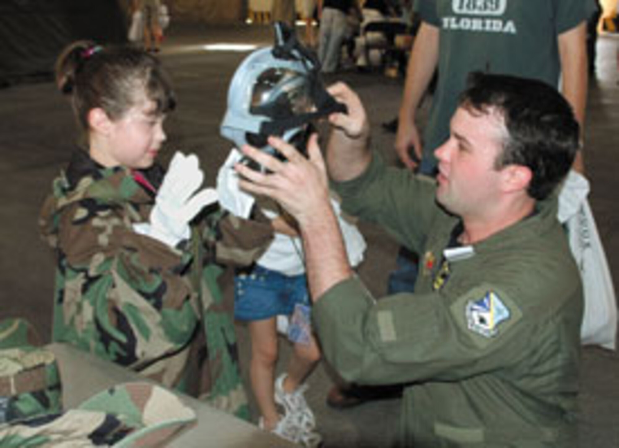 TINKER AIR FORCE BASE, Okla. — Staff Sgt. Daric Franco, 965th Airborne Air Control Squadron, fits 9-year-old Kylee Johnson with protective gear at Camp Courage. (Air Force photo by Ralph Monson)

