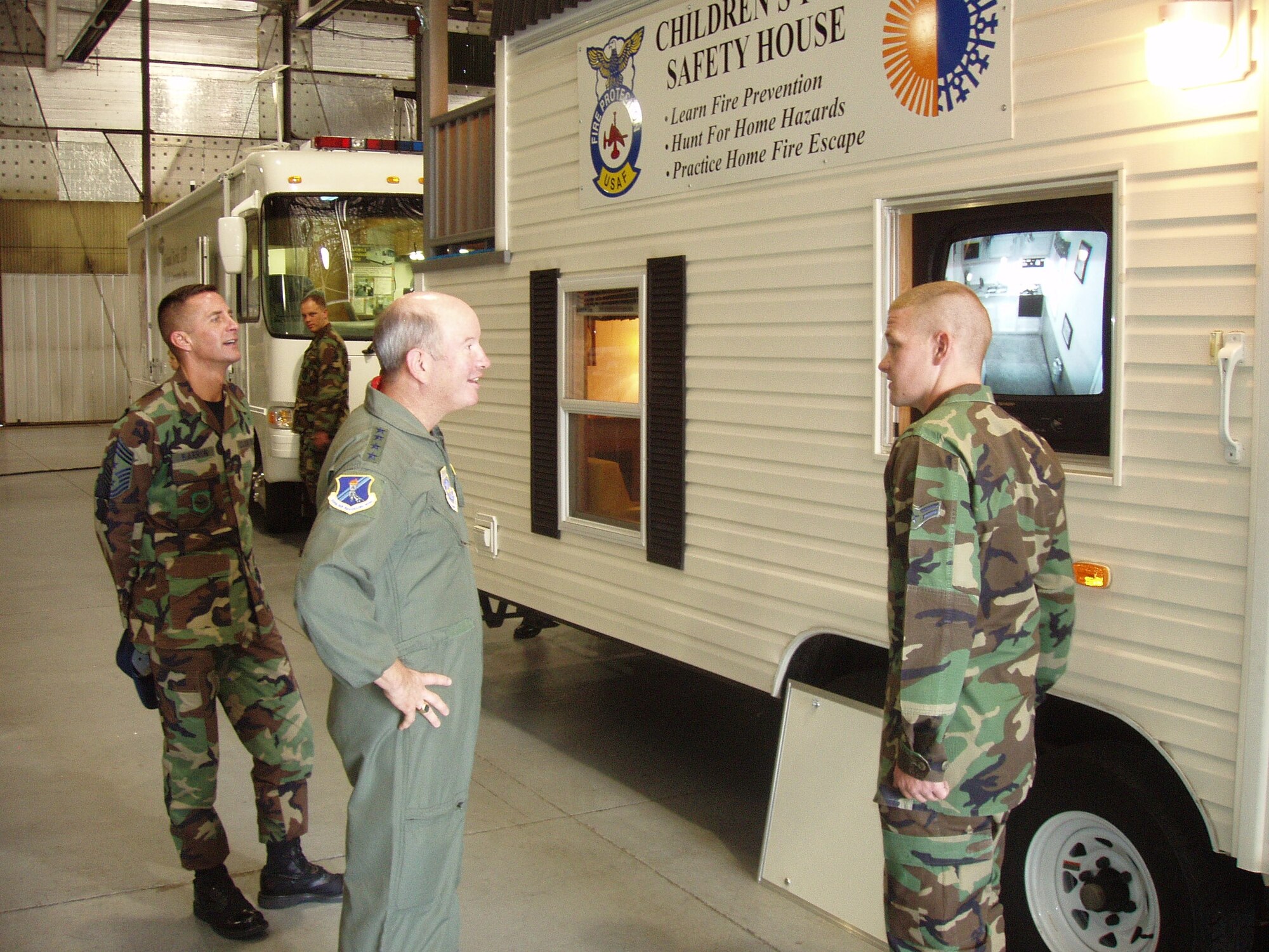 Airman 1st Class Alexander Lemieux, 319th Civil Engineering Squadron, shows the children’s fire safety house to General McNabb and Chief Master Sgt. Joseph Barron, AMC command chief. He is one of many Airmen to showcase their mission at Warrior Land Sept. 13.