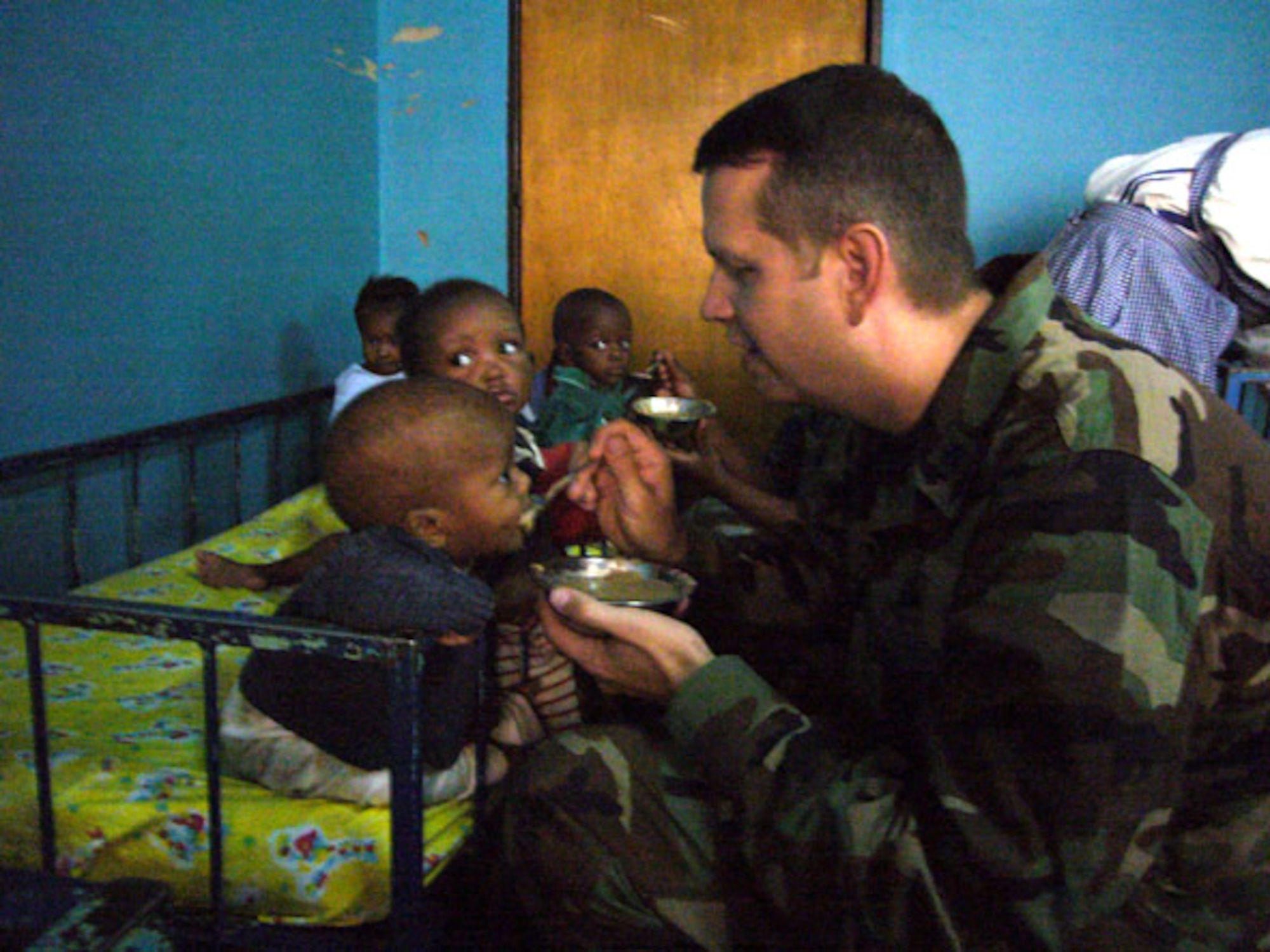Lt. Col. Jeffrey Renner feeds a Rwandan orphan during a visit in Kigali by Airmen from Ramstein Air Base, Germany. The Airmen delivered school supplies, clothing and blankets donated by the Kaiserslautern Military Community. Colonel Renner is commander of the 787th Air Expeditionary Squadron. (U.S. Air Force photo/Capt. Erin Dorrance) 