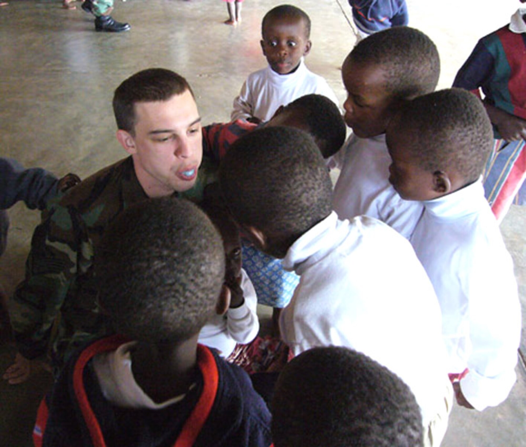 Staff Sgt. Jack Brown teaches Rwandan orphans how to blow a bubble with gum during a visit at an orphanage in Kigali. Airmen from Ramstein Air Base, Germany, delivered donations collected from the Kaiserslautern Military Community. Sergeant Brown is assigned to the 700th Contracting Squadron. (U.S. Air Force photo/Capt. Erin Dorrance)
