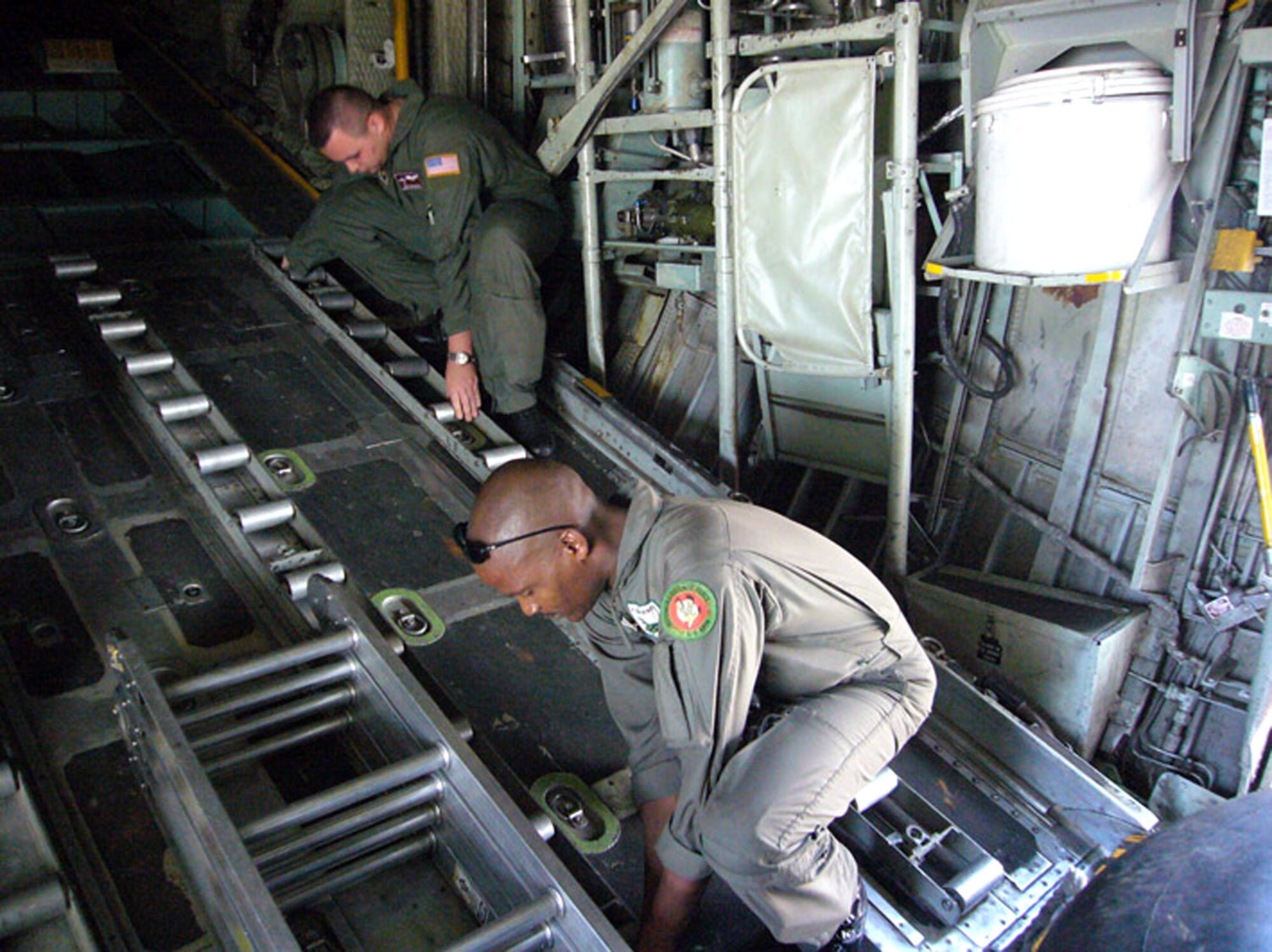 Botswana Defence Force Cpl. Ezekiel Merafe, C-130 loadmaster, and Air Force Staff Sgt. Vern Miles, 86th Operations Support Squadron C-130 loadmaster, prepare the back of a C-130 for cargo Sept. 24 at the Kigali International Airport in Rwanda. (U.S. Air Force photo/Capt. Erin Dorrance)

