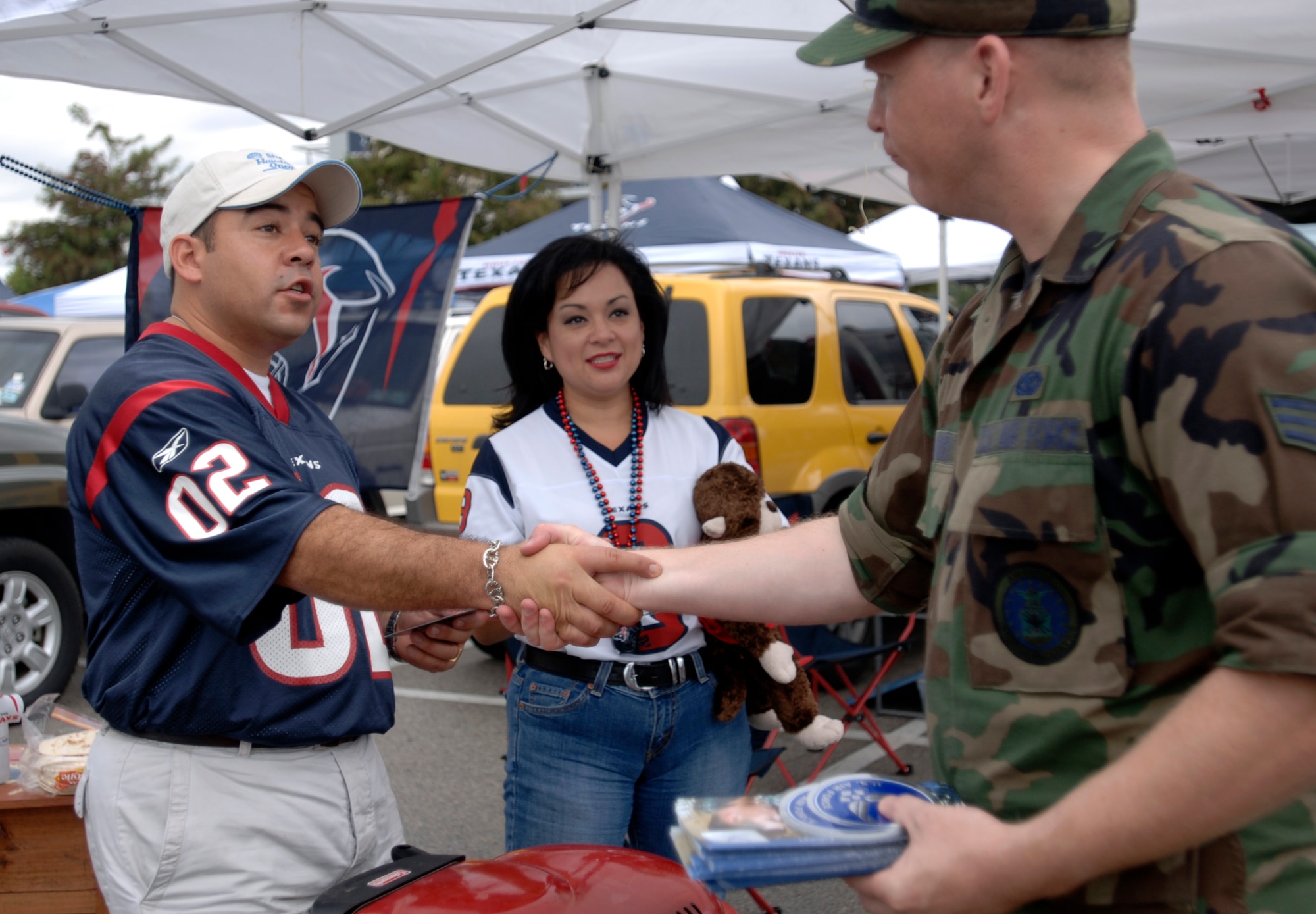 Senior Airman Dylan Bolander talks about the Air Force with Houston Texans fans' Dominic and Chantella Villareal during tailgating activities before the Houston Texans and Washington Redskins game at Reliant Stadium in Houston Sept 24. The game was designated as the Houston Texans' Salute to the Military day by team officials. (U.S. Air Force photo/Tech. Sgt. Cecilio M. Ricardo Jr.)